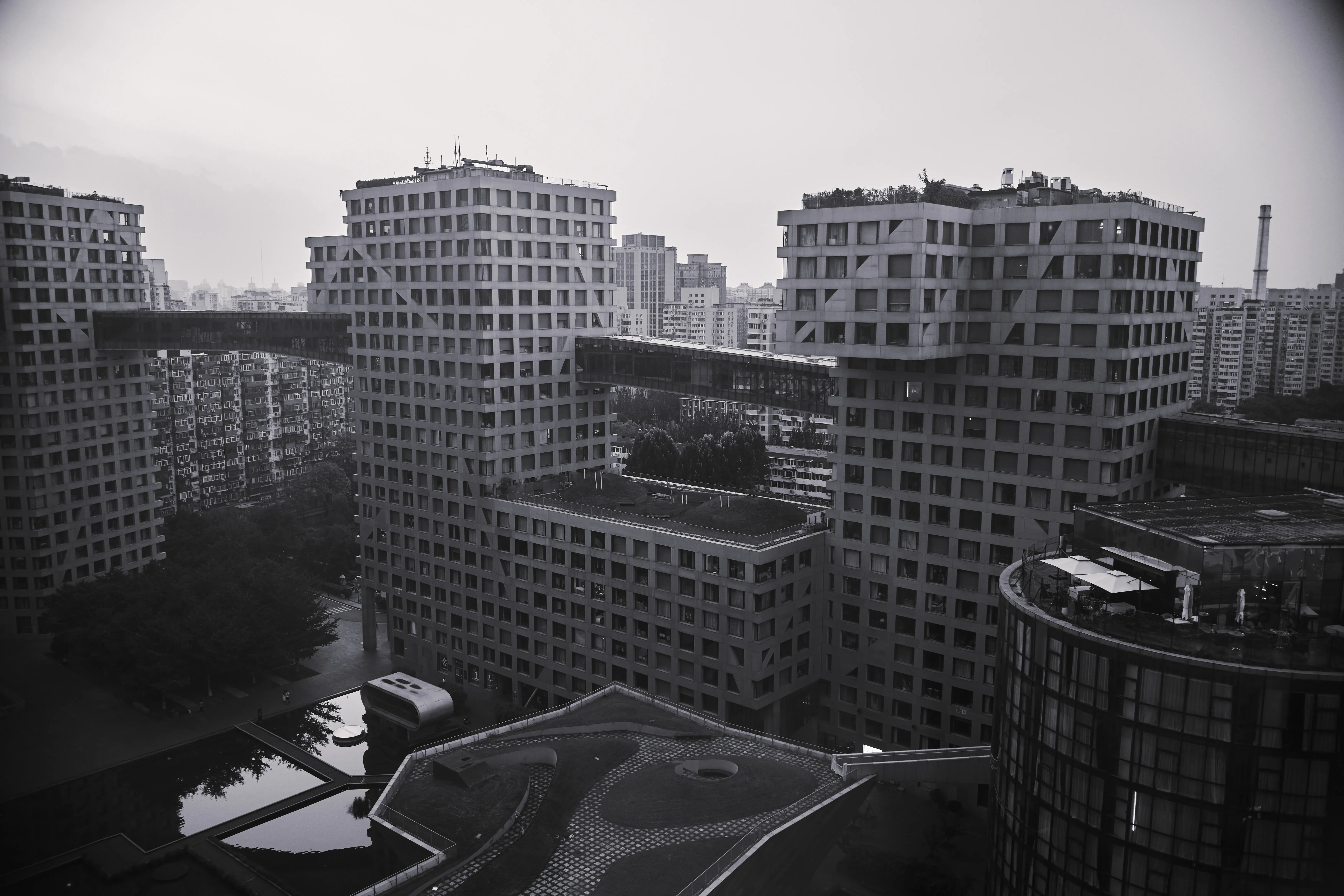 灰雾里的连廊穿过方格建筑，黑白城市被切成悬置的体块。