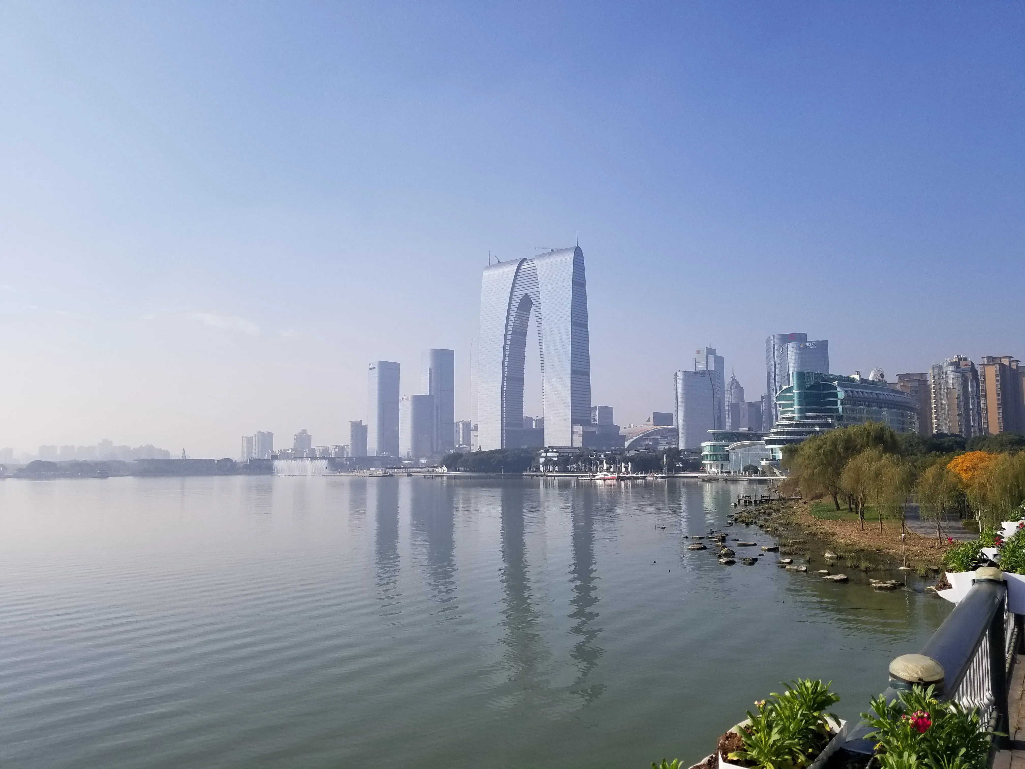 平静湖面映着苏州天际线，早晨的城市尚未喧闹。