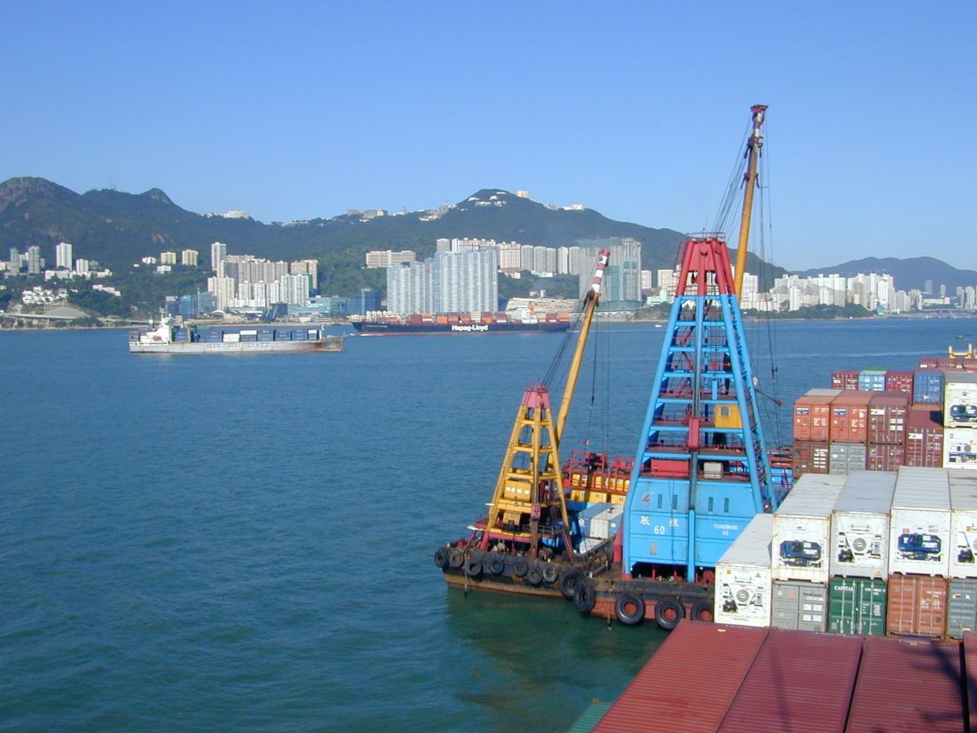 Hong Kong 2005 at anchor, two barges with cranes (floating derricks) on the port side