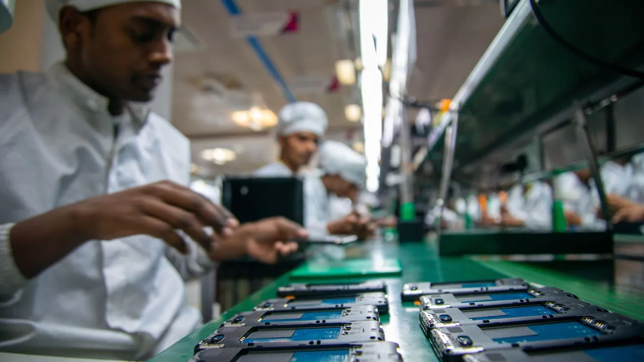 Workers assembling smartphones on a mobile phone production line in India.