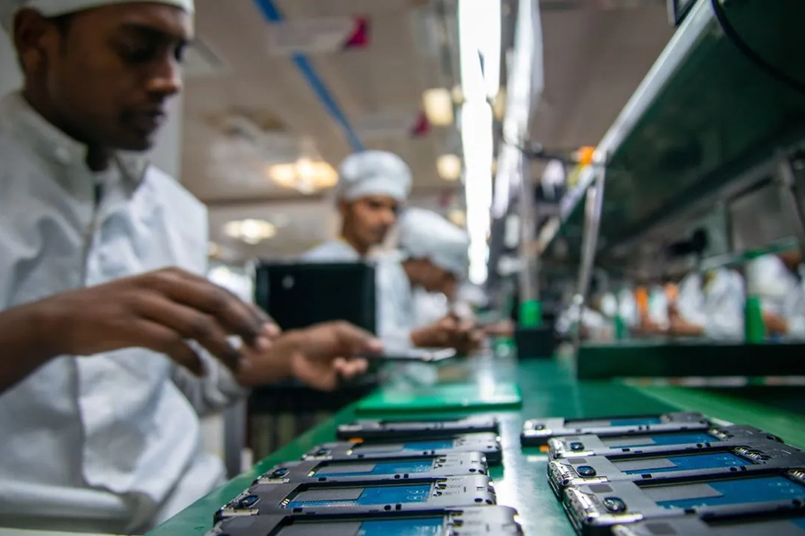 Workers assembling smartphones on a mobile phone production line in India.
