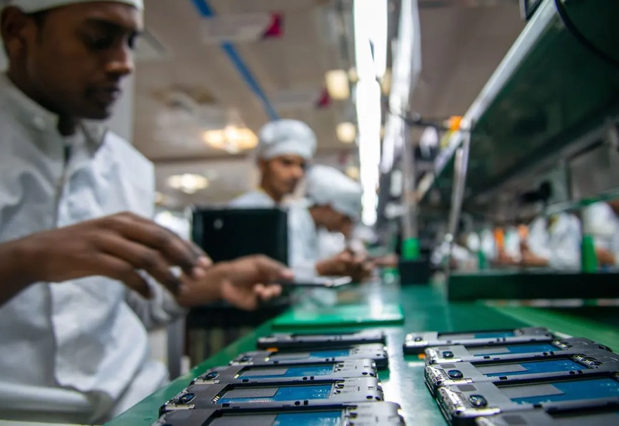 Workers assembling smartphones on a mobile phone production line in India.