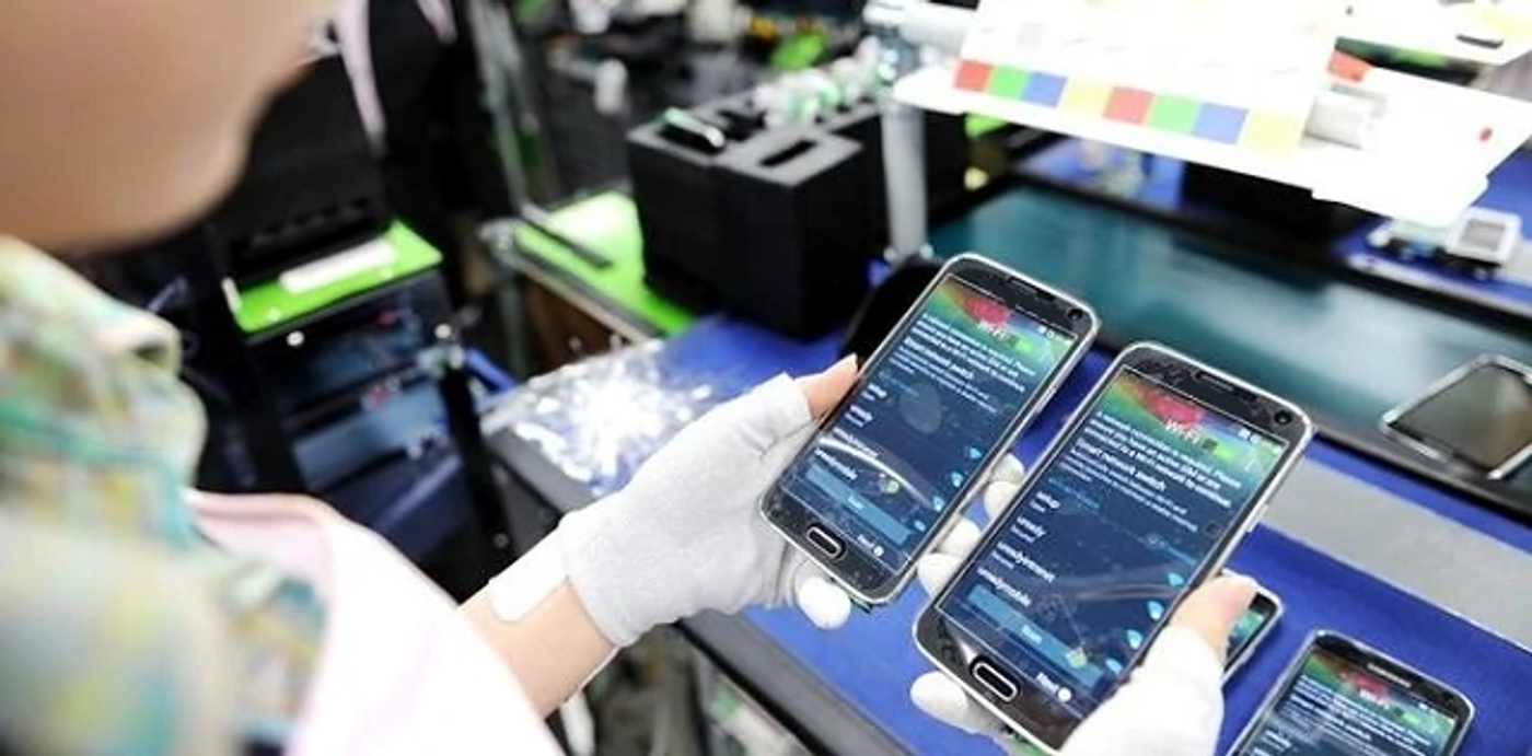 Smartphones being assembled and inspected on an electronics production line.