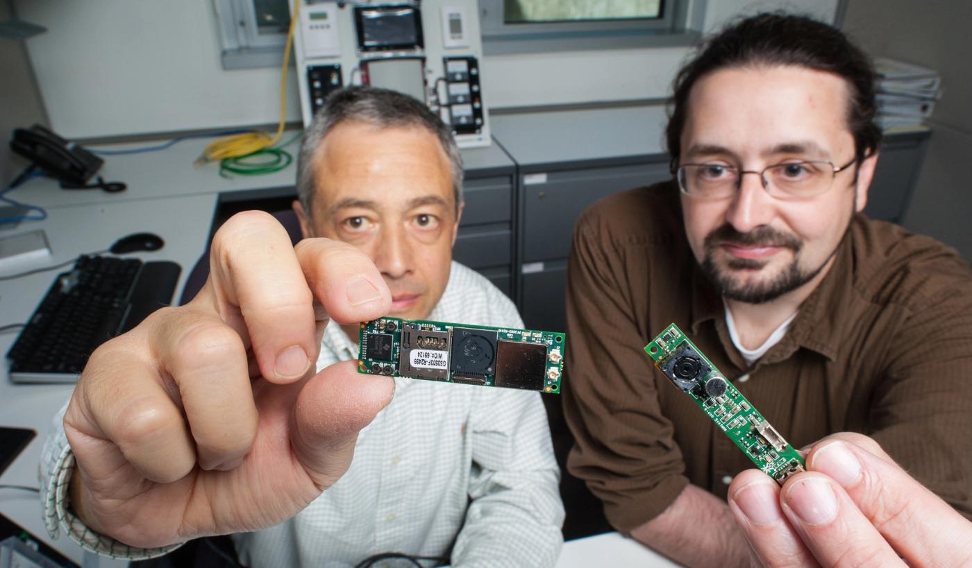 March 05, 2013 -NREL researchers Luigi Gentile Polese , left and Larry Brakney hold the processor and camera that make up the Image Processing Occupancy Sensor (IPOS). The sensor is based on commercia