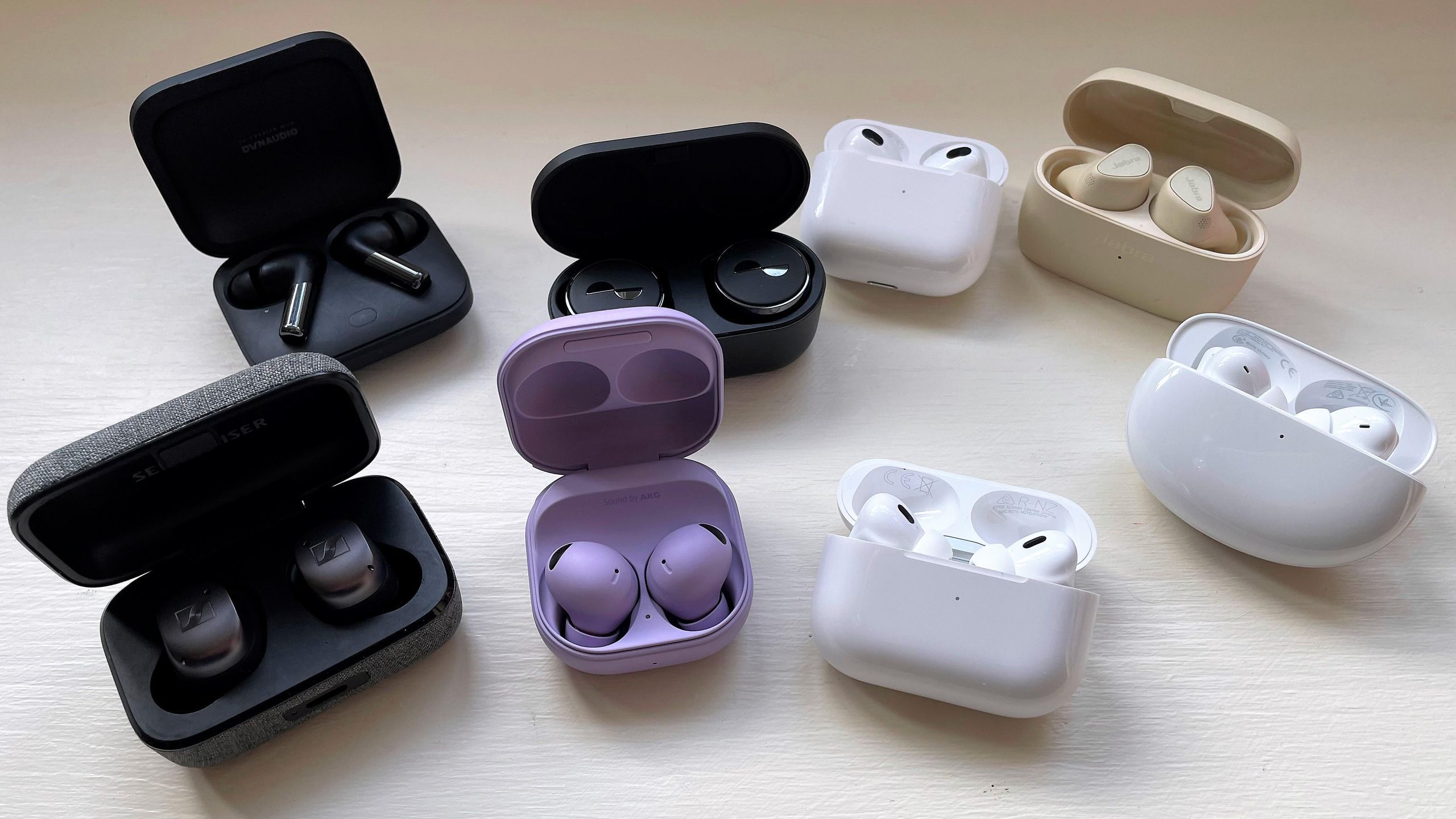 A selection of true wireless earbuds displayed in their charging cases.