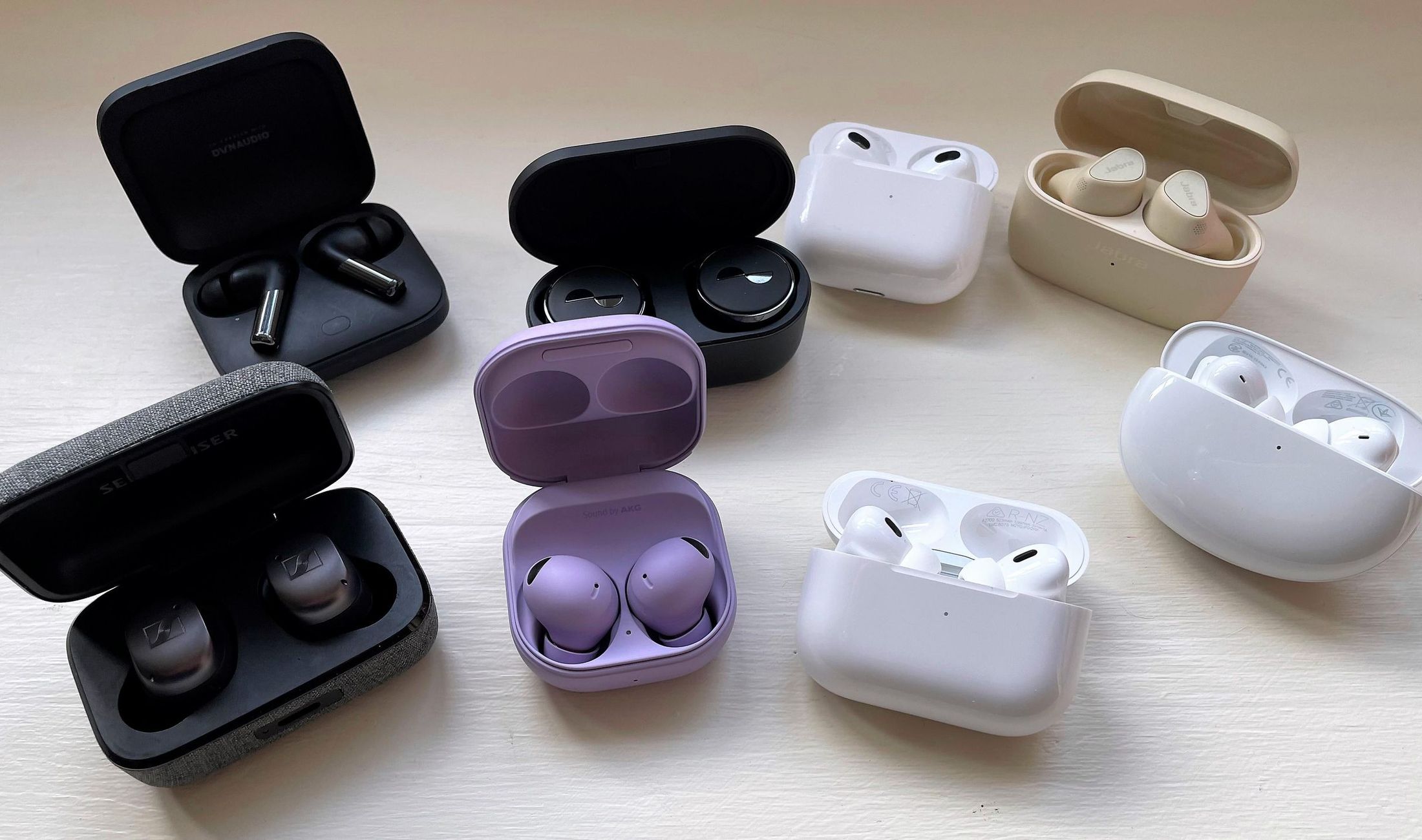 A selection of true wireless earbuds displayed in their charging cases.