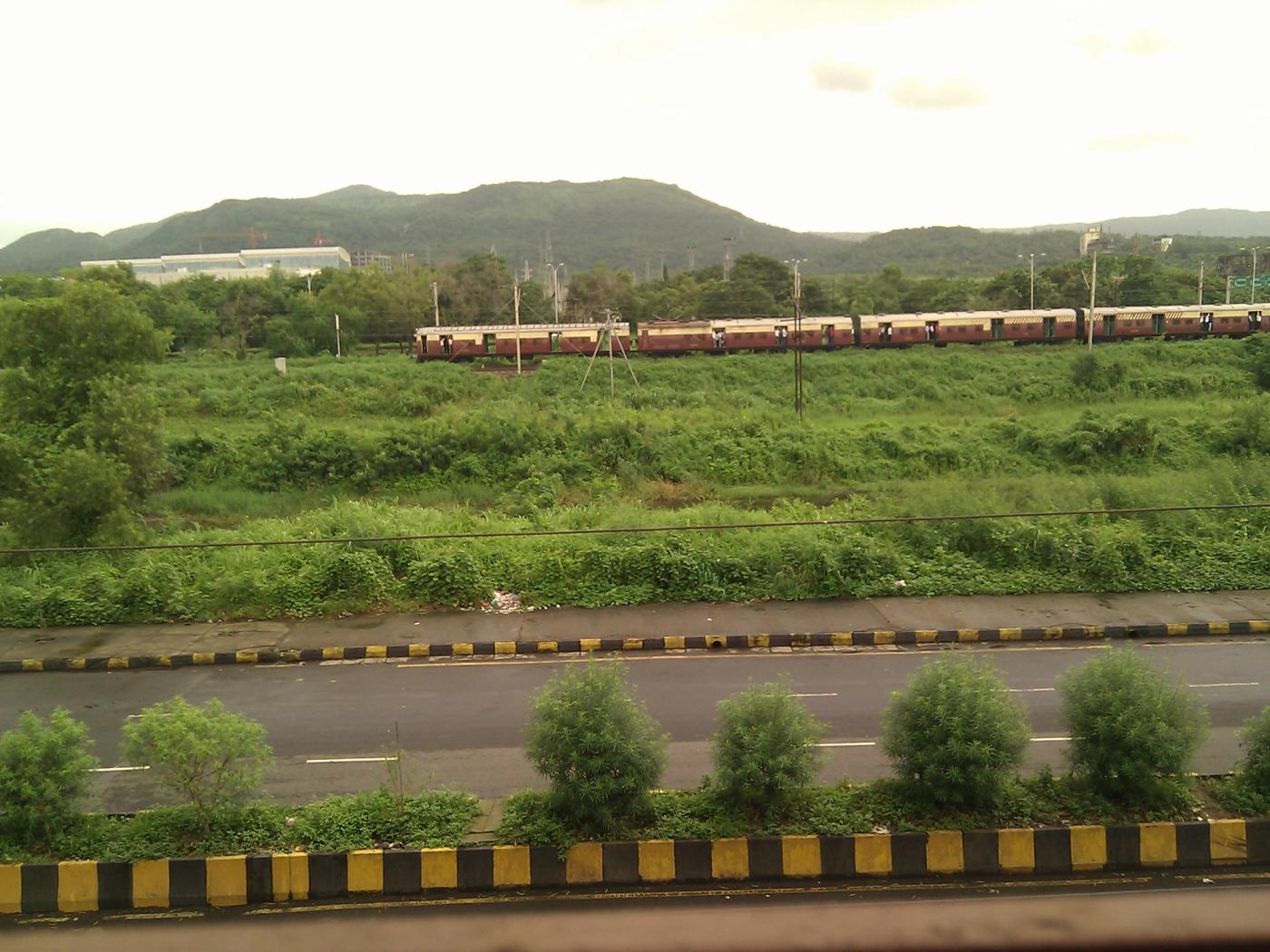 Local train with reliance corporate IT park in the background