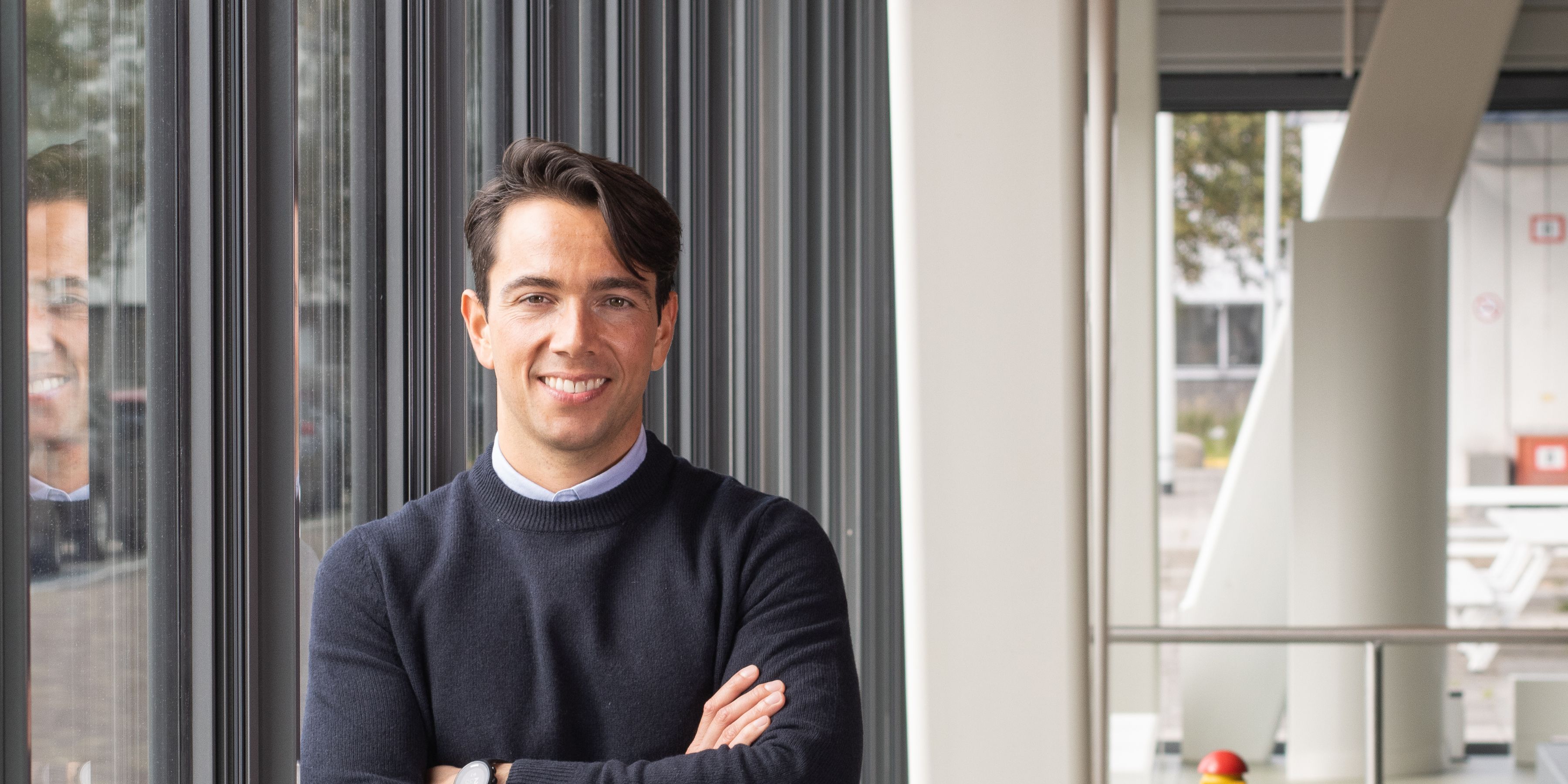 Een KLM medewerker poseert voor de camera op kantoor