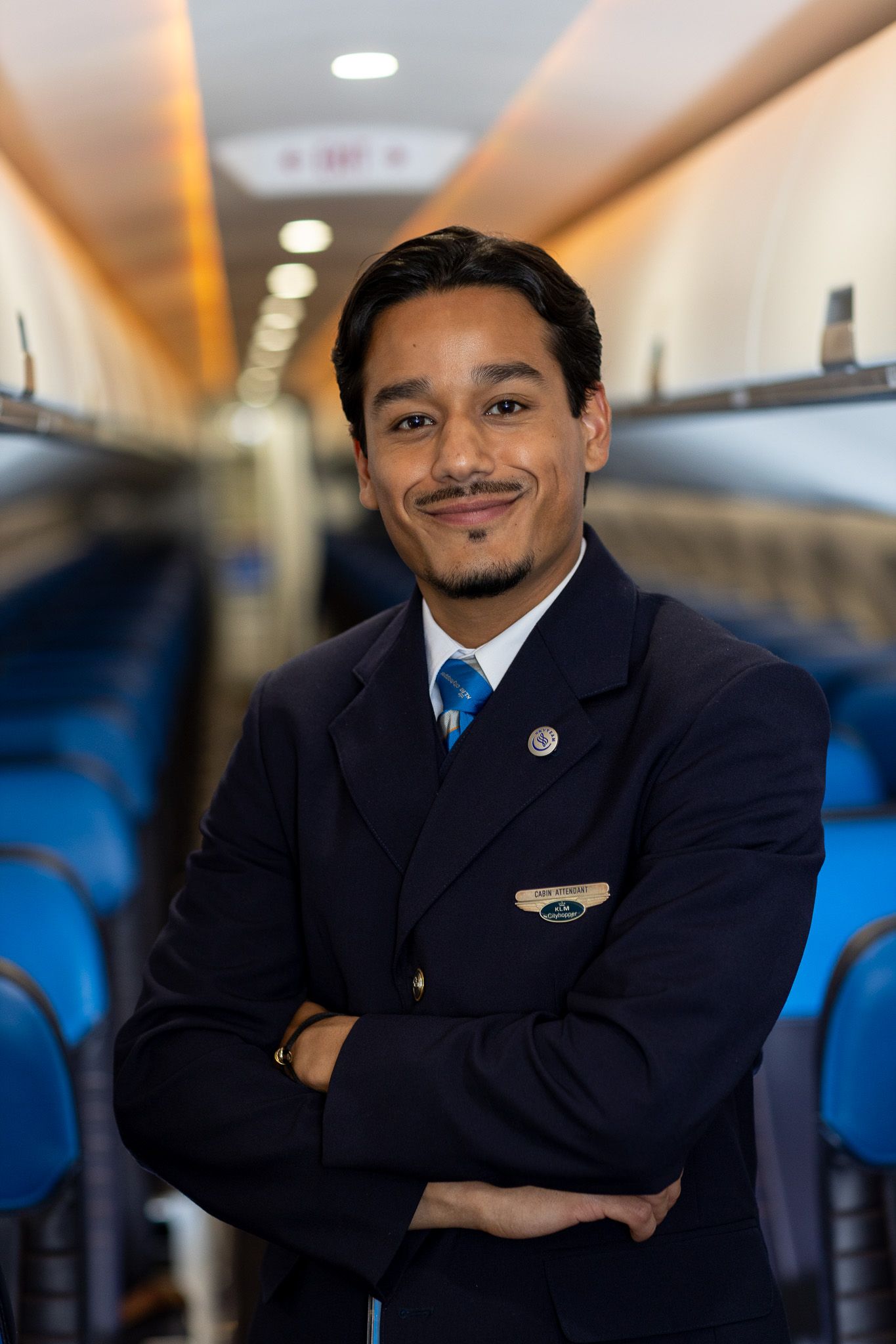 KLM Cityhopper cabin attendant standing in the middle of the aircraft
