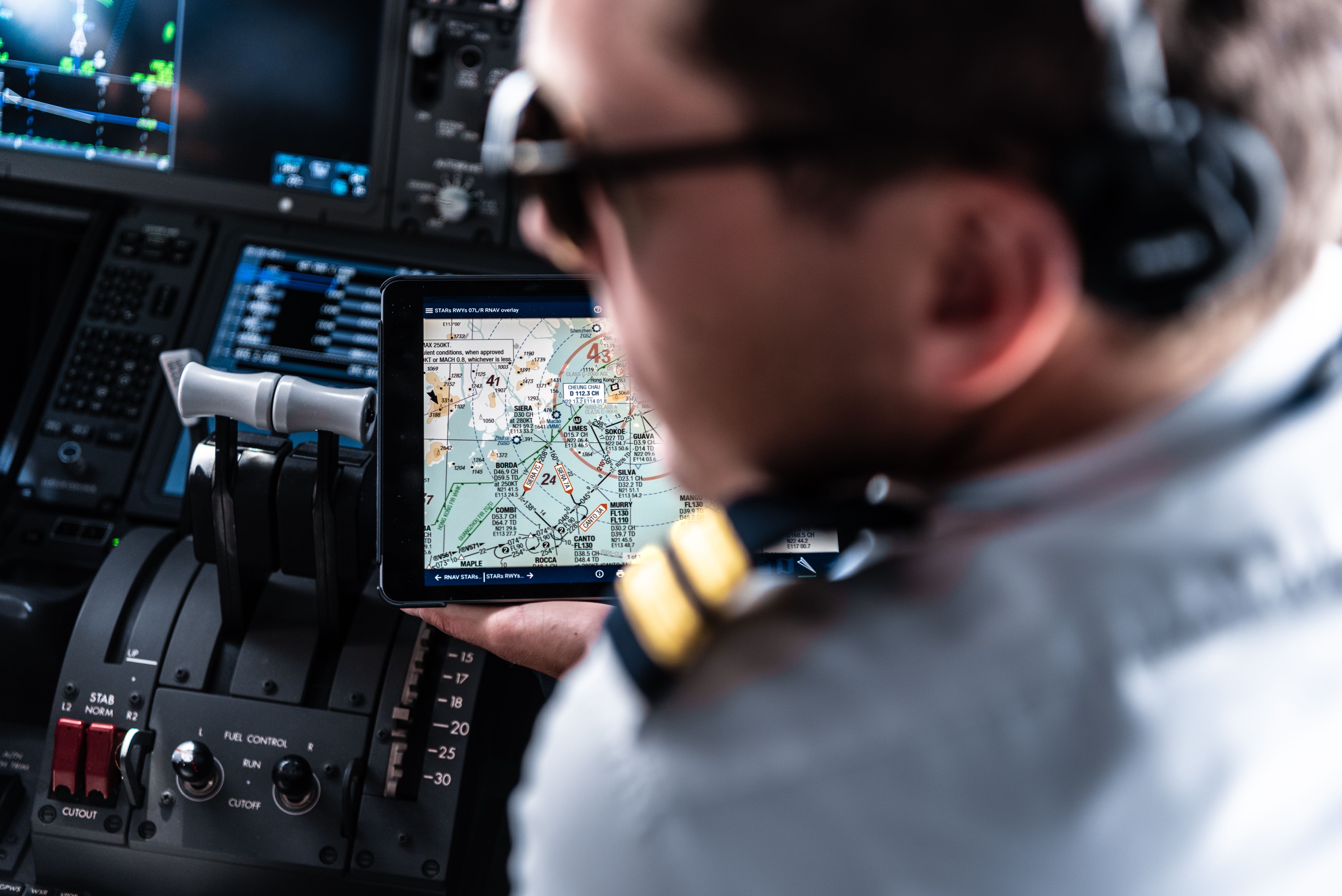 A photo taken over the should of a pliot with clear view on an ipad