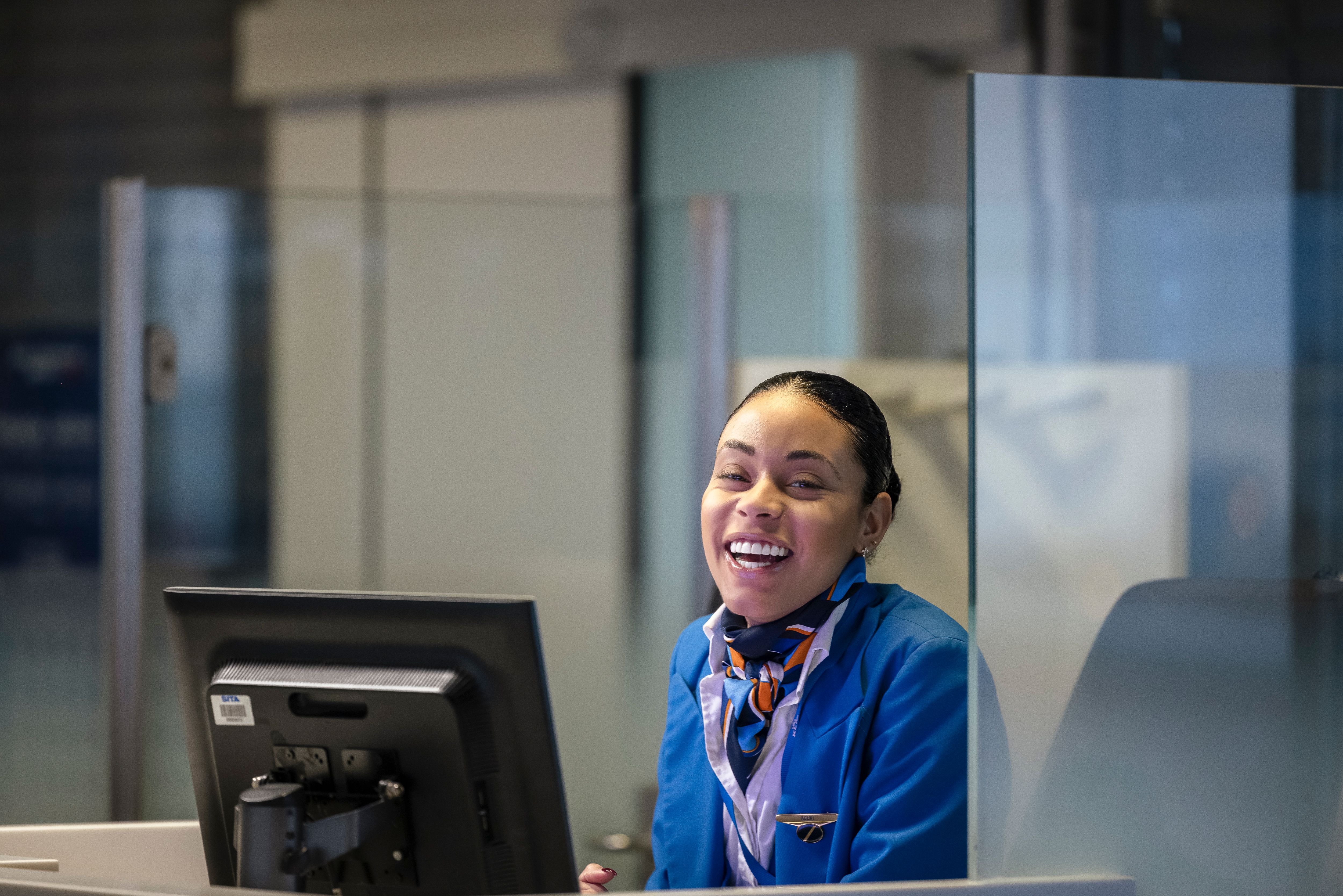 A smiling service agent at airport desk