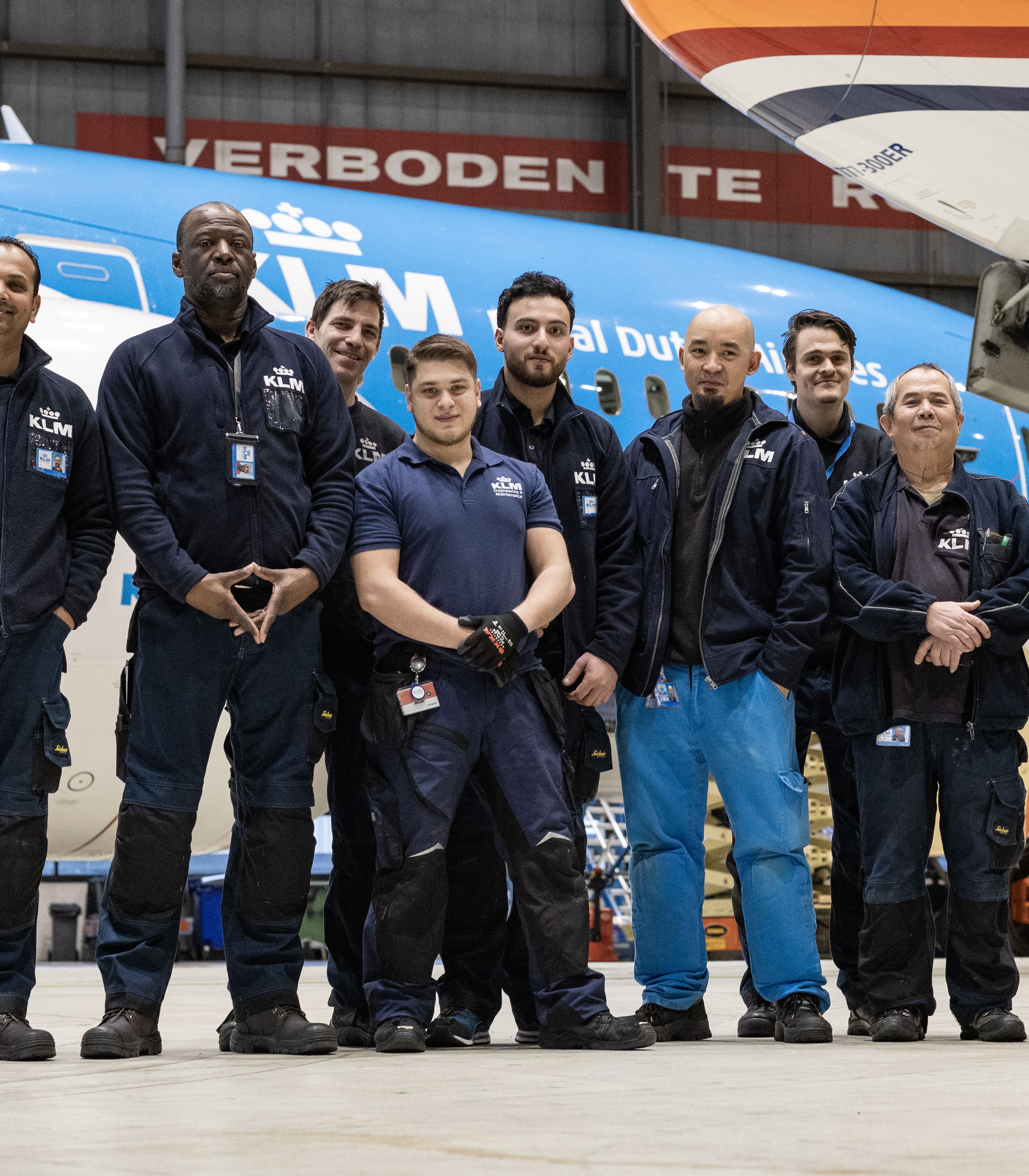 Group photo of aircraft maintenance team standing in front of a KLM airplane inside a hangar