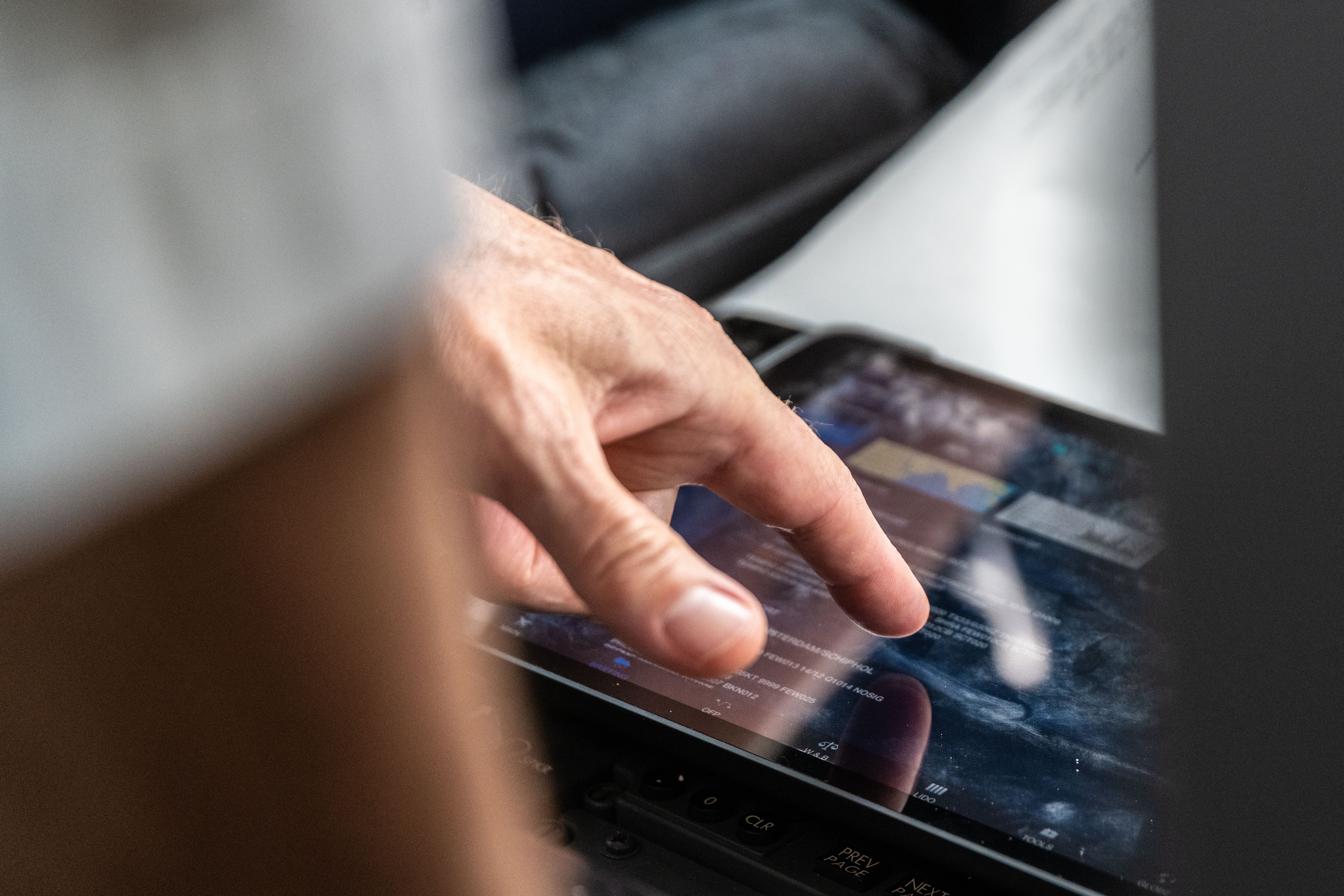 Detailed shot of a KLM pillot using his Ipad