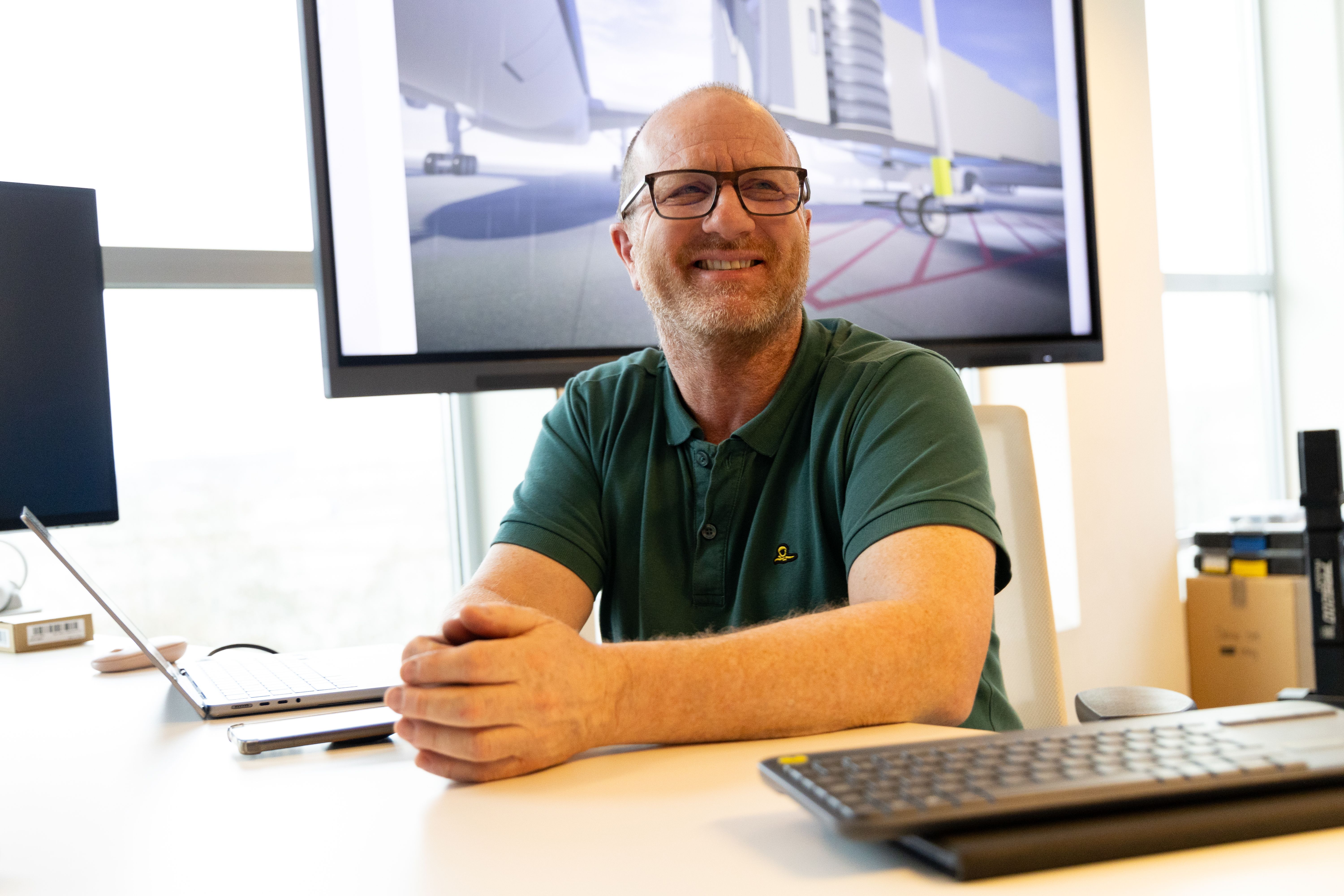 KLM colleague smiling behind a desktop