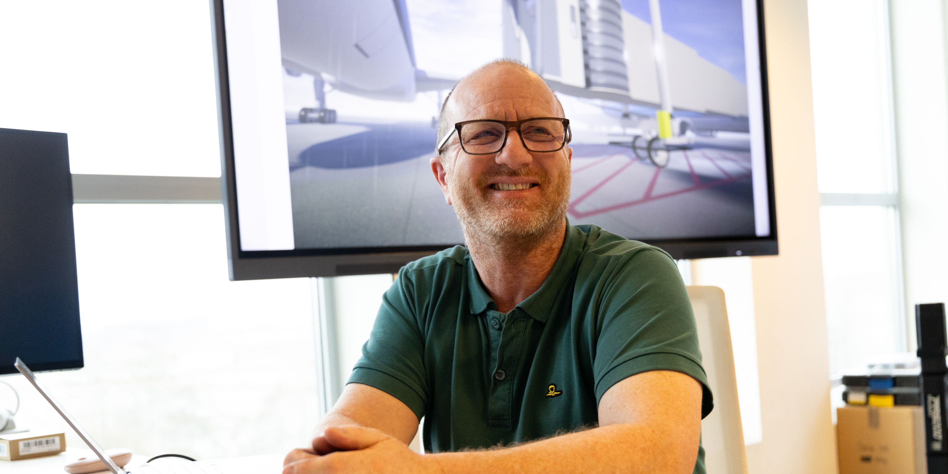 KLM colleague smiling behind a desktop