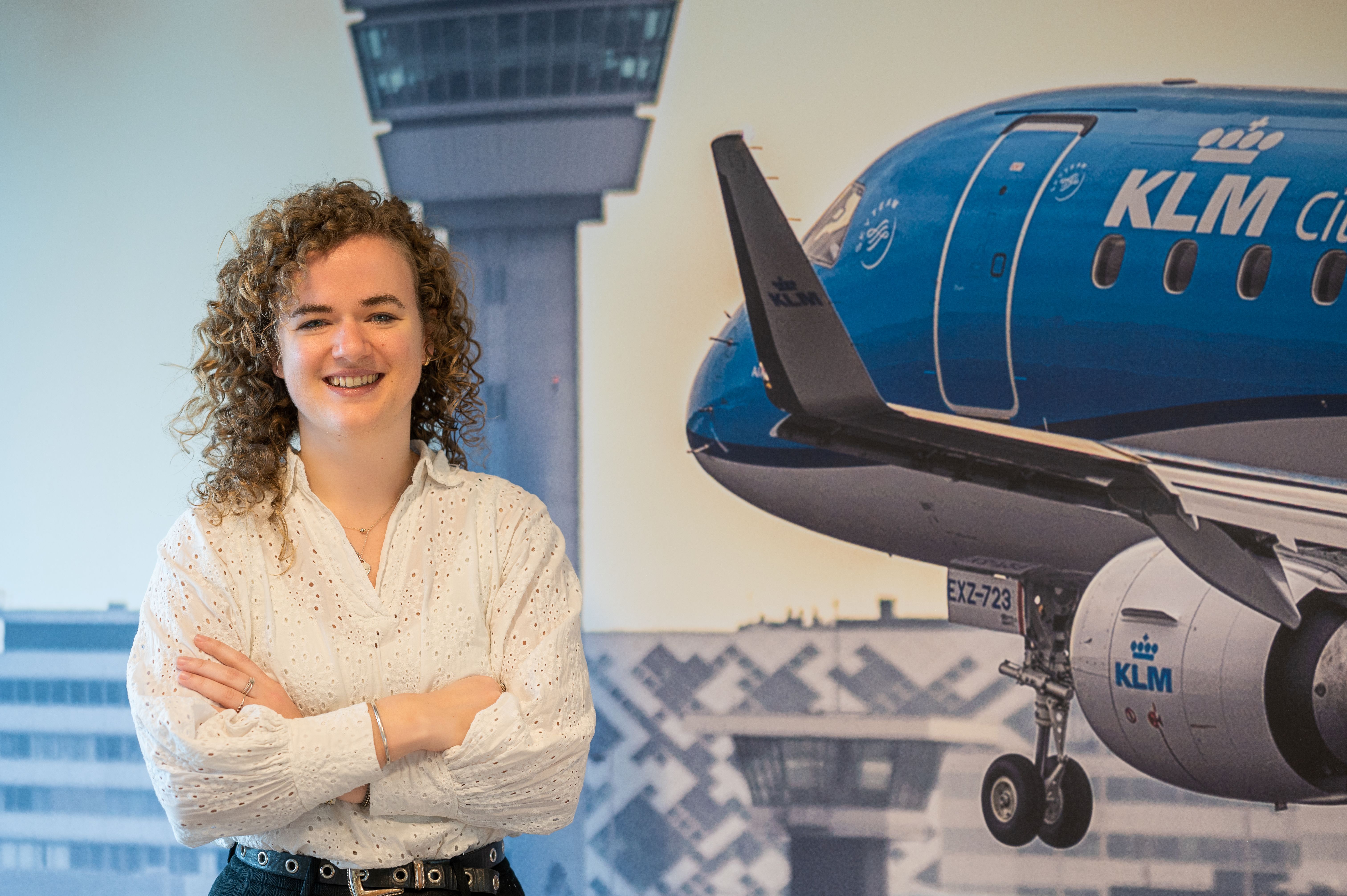 Vrouwelijke collega van de financële afdeling staat voor een foto van een vliegtuig