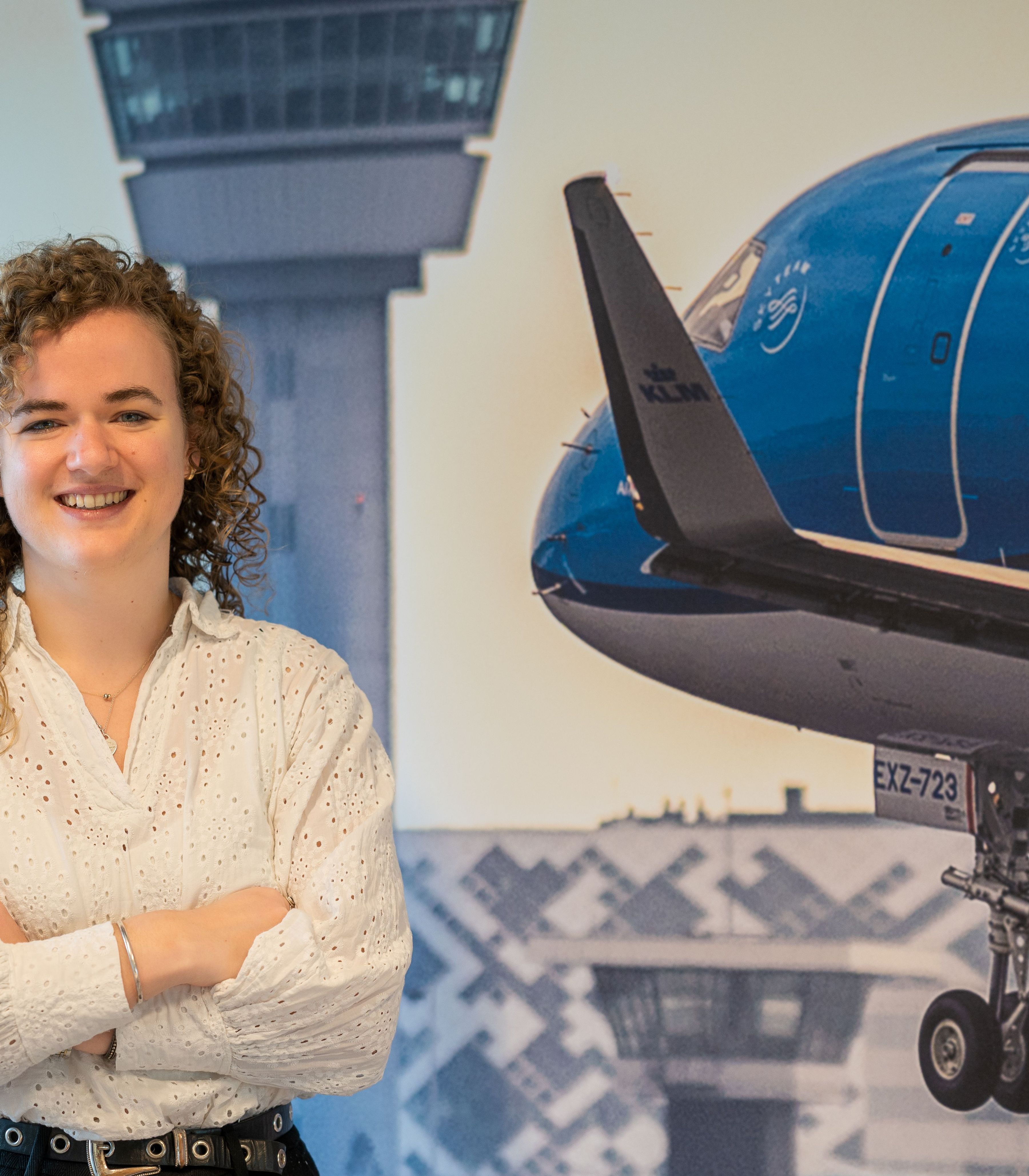 Vrouwelijke collega van de financële afdeling staat voor een foto van een vliegtuig