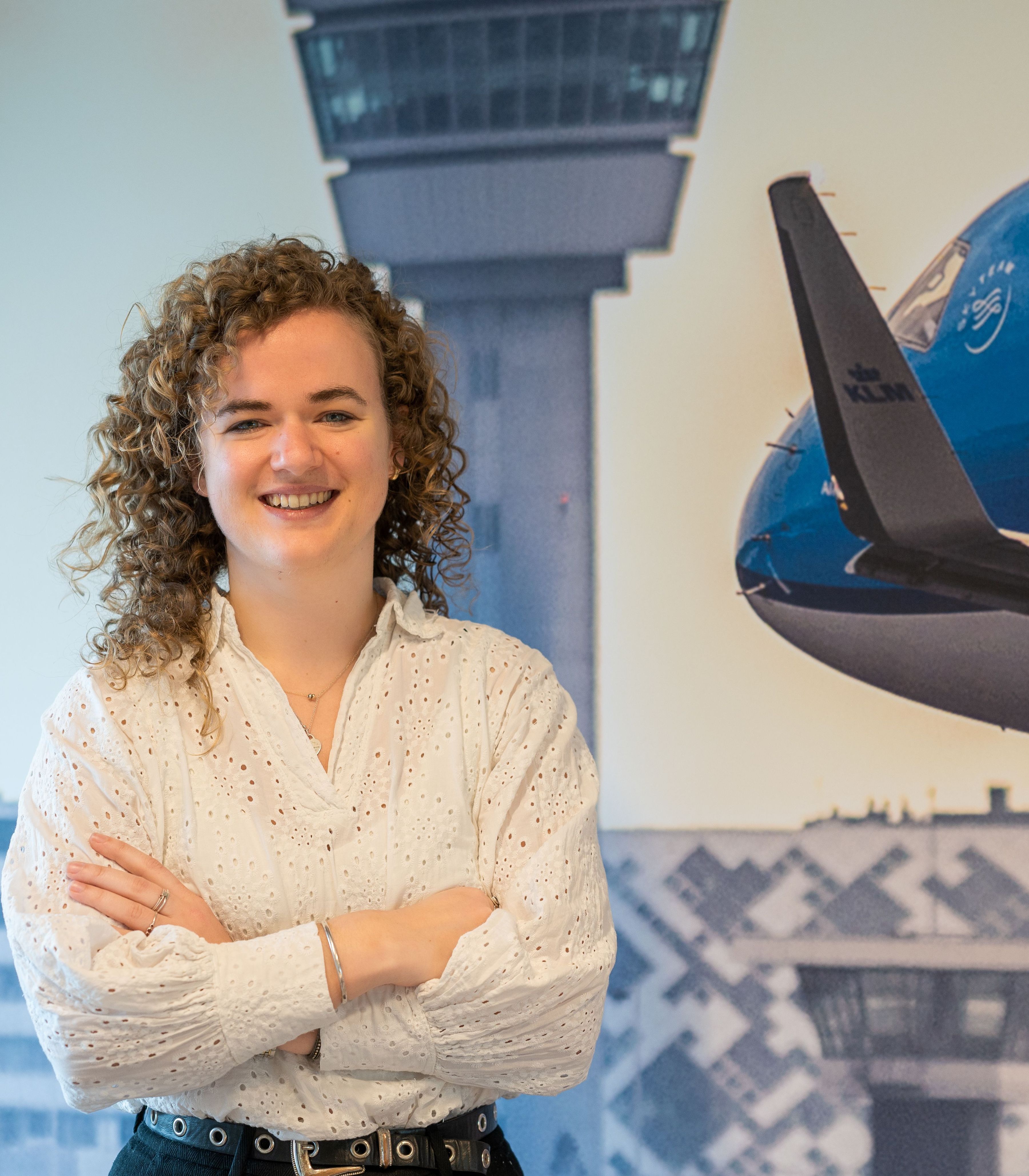 Vrouwelijke collega van de financële afdeling staat voor een foto van een vliegtuig
