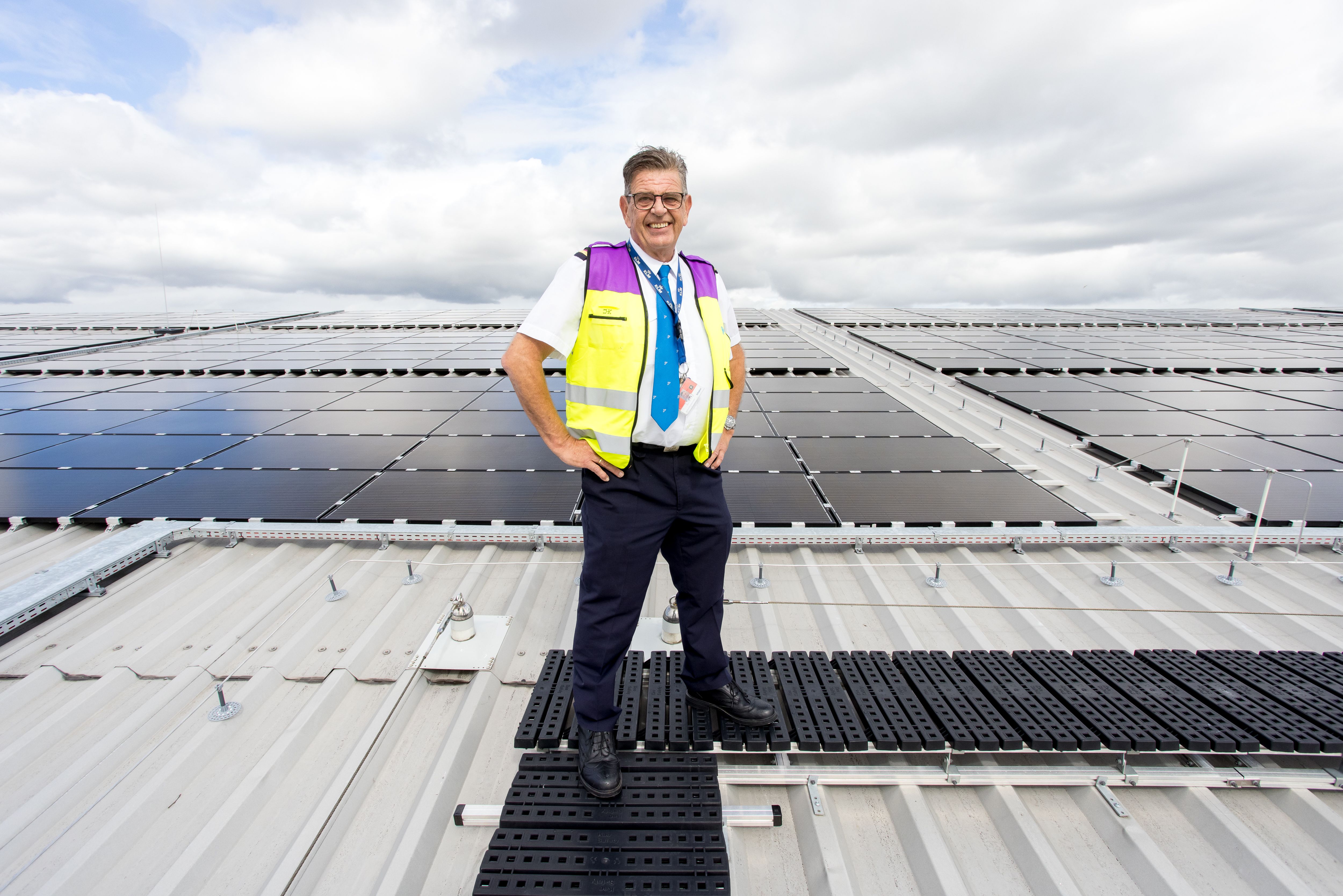 Employee on hanagr roof with solar panels