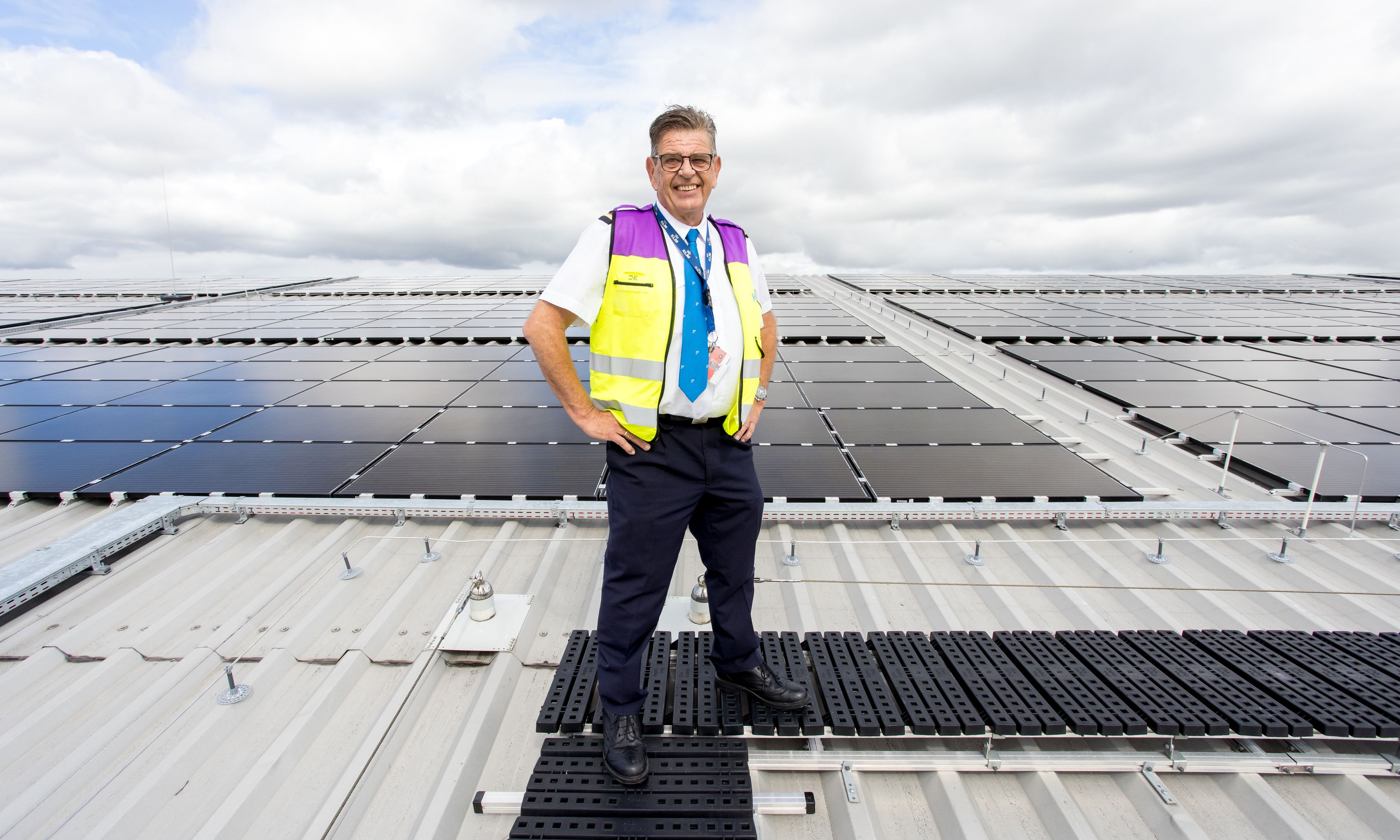 Employee on hanagr roof with solar panels