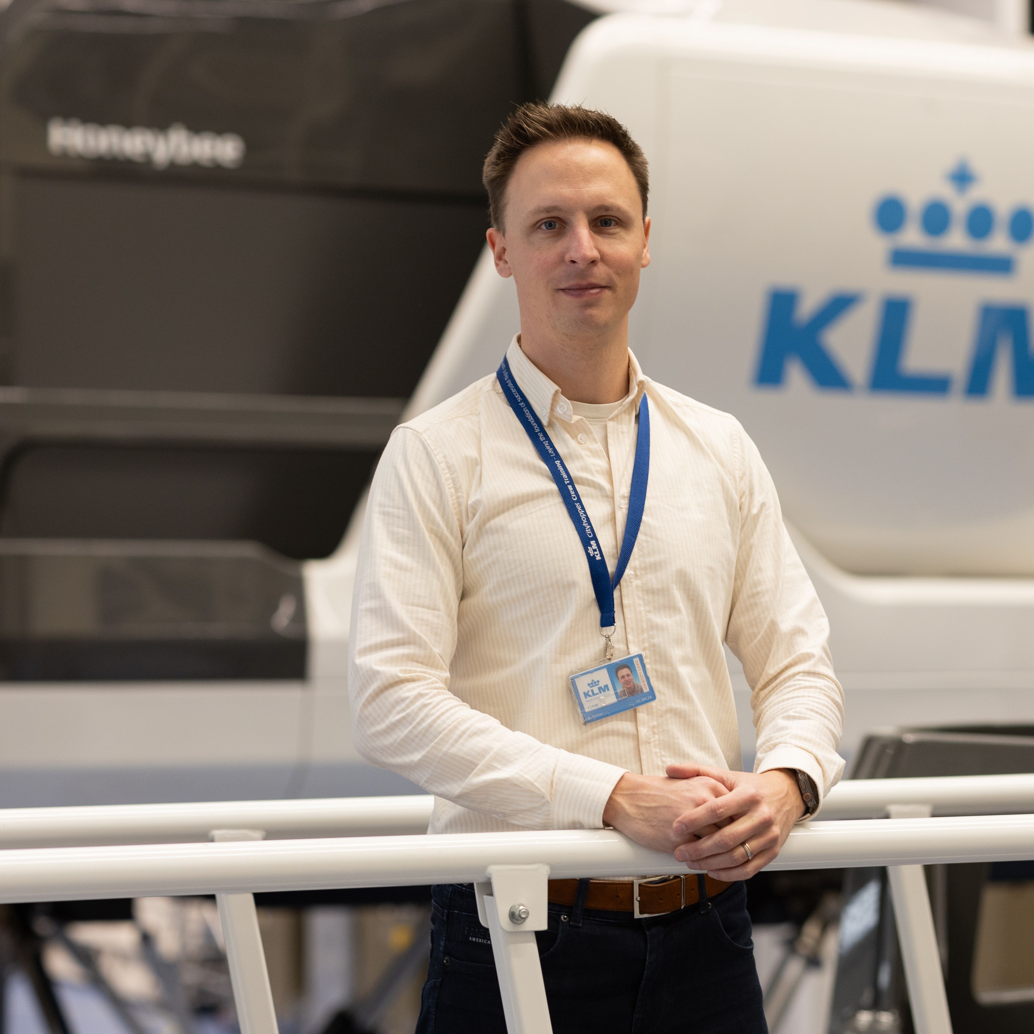 KLM colleague standing in front of a flight simulator