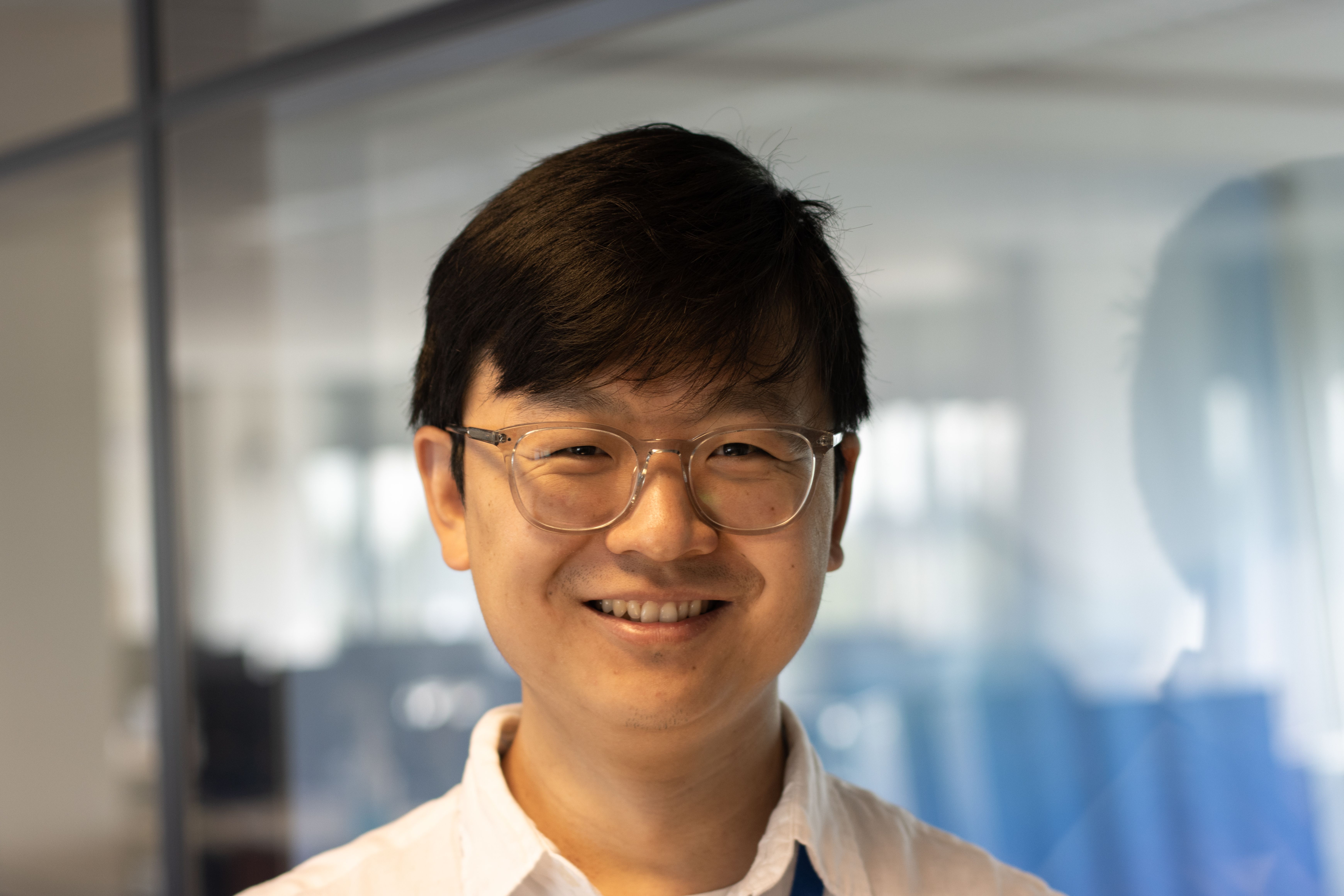 Aziatische medewerker van de financiële afdeling kijkt recht in de camera.