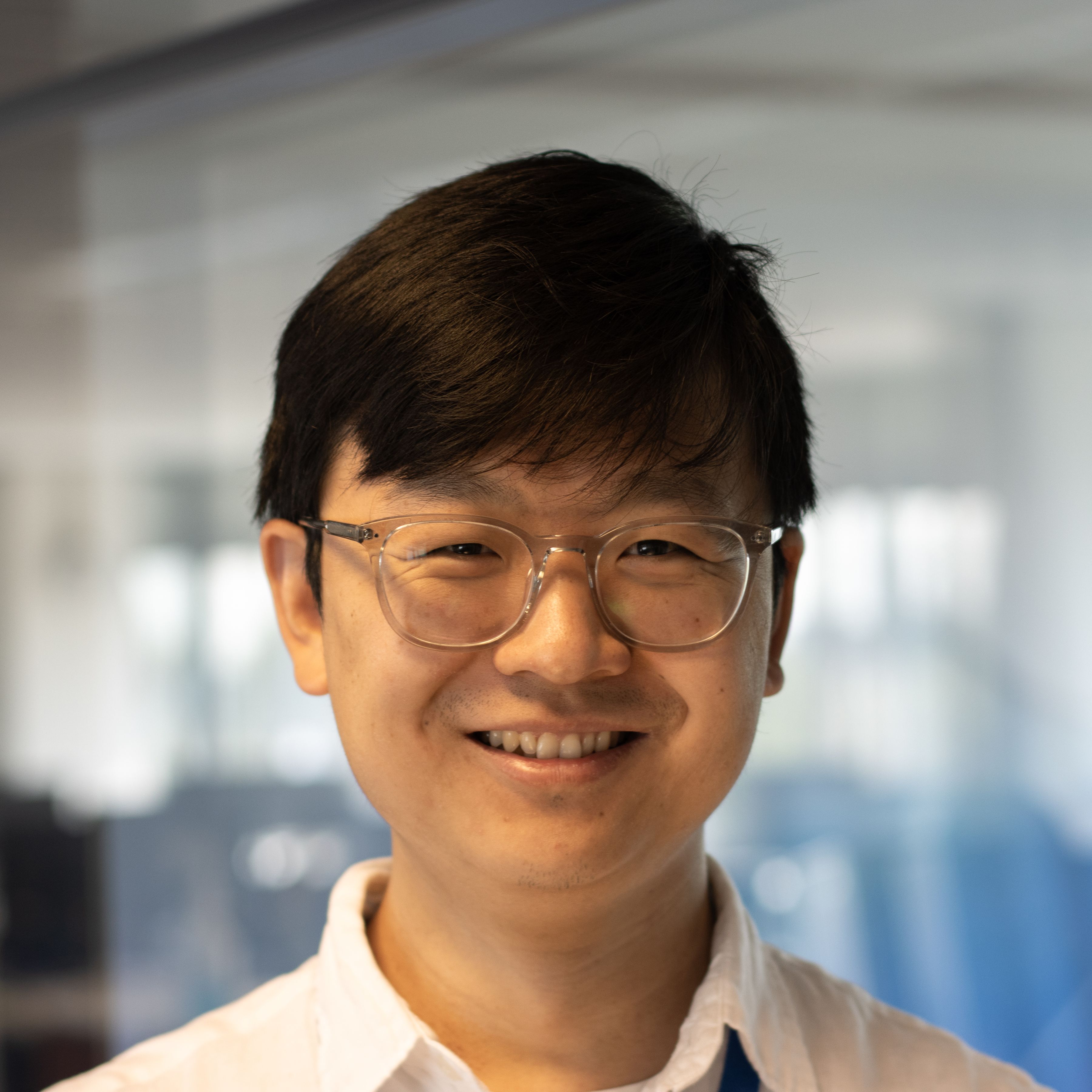 Aziatische medewerker van de financiële afdeling kijkt recht in de camera.