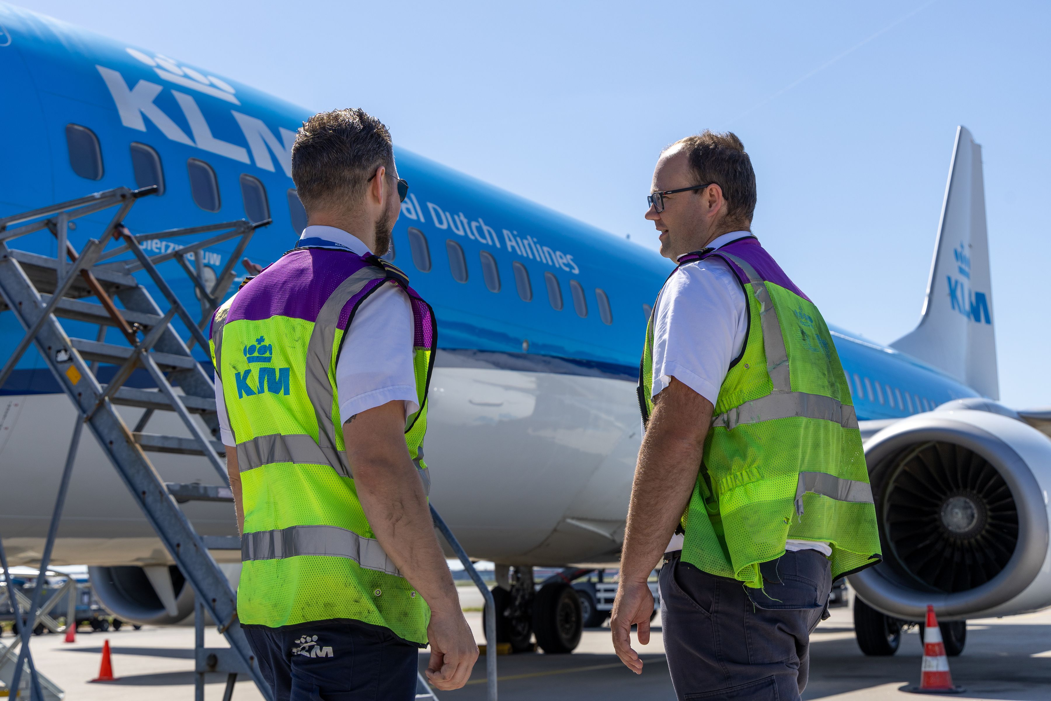 2 KLM colleagues discussing in front of an aircraft on the platform