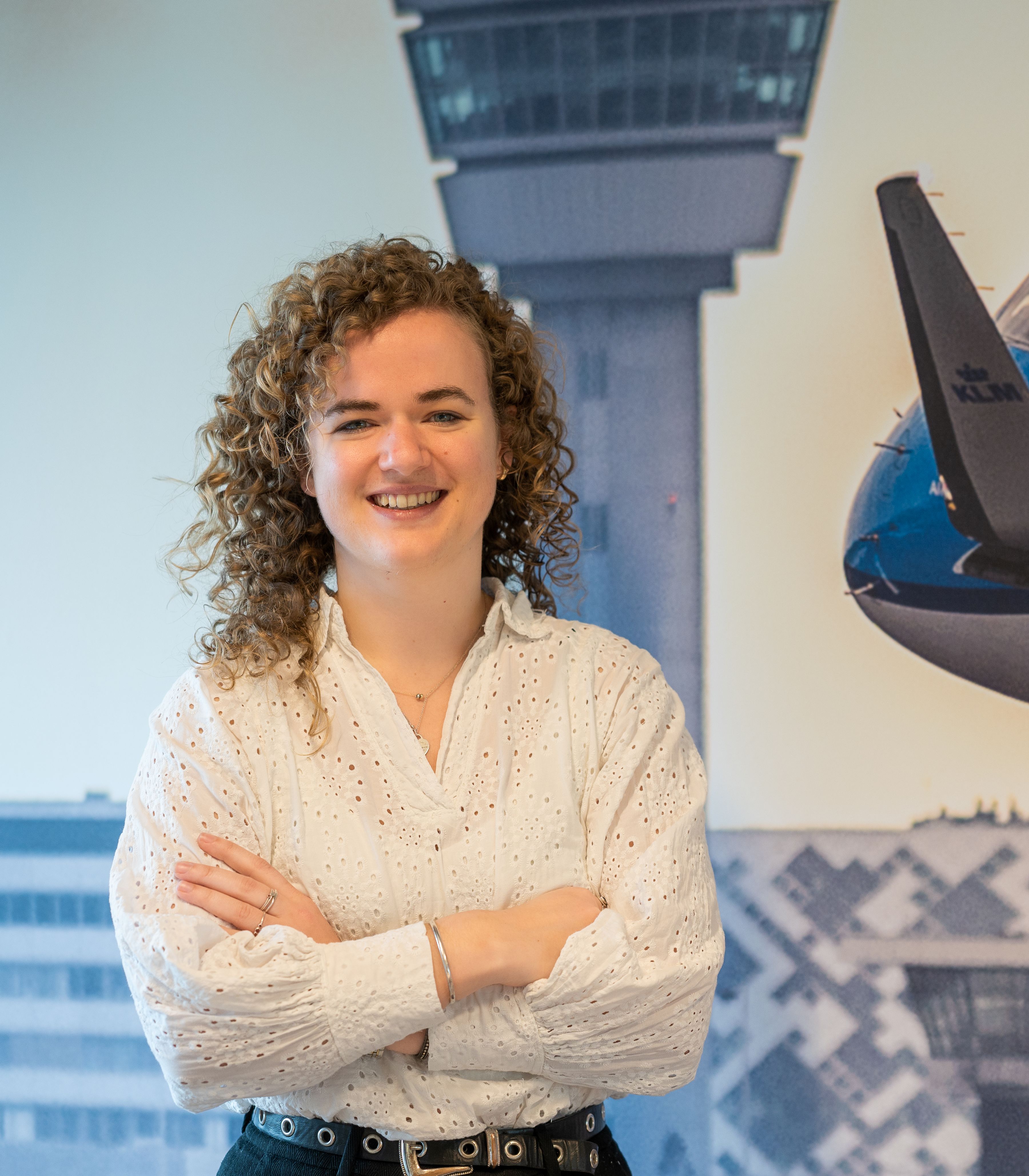 Finance colleague standing in front of abig photo of an aircarft