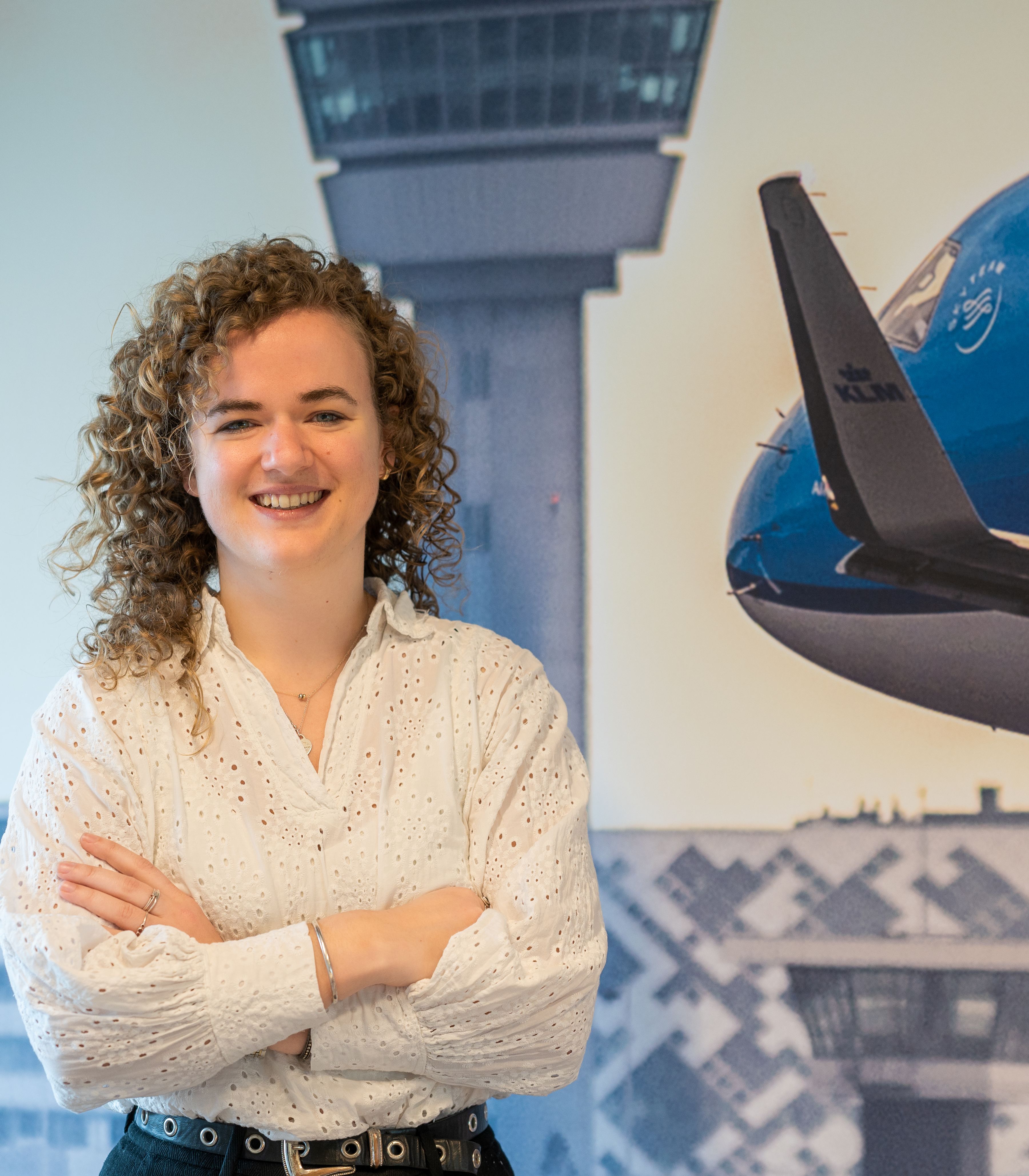 Finance colleague standing in front of abig photo of an aircarft