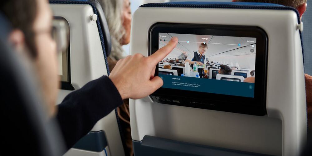 Man pointing at inflight entertainment system