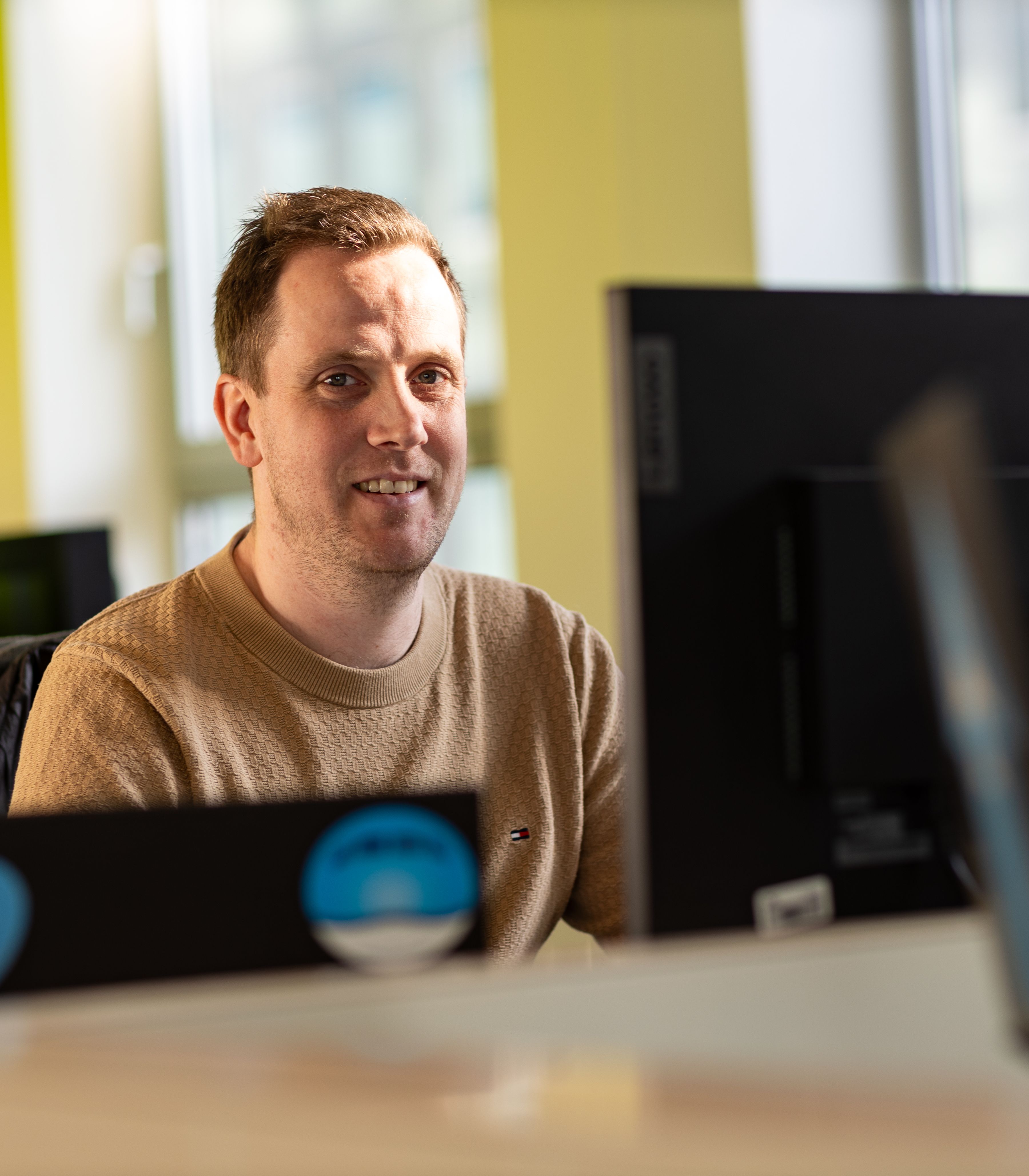 KLM IT-collega aan het werk op zijn laptop