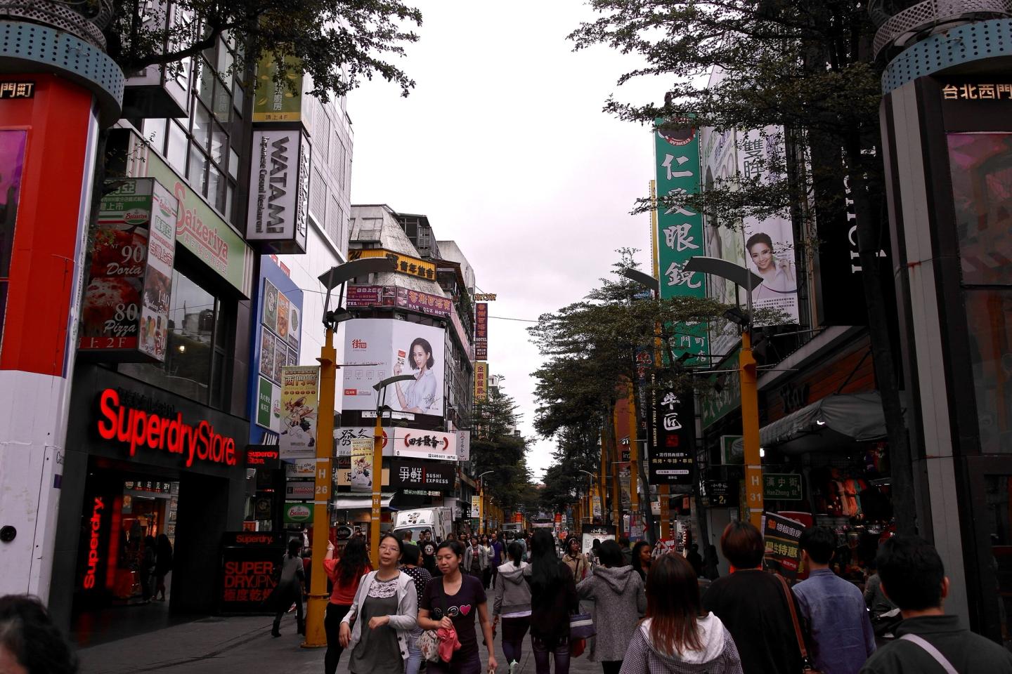 Pedestrians and illuminated signs on a Ximending street