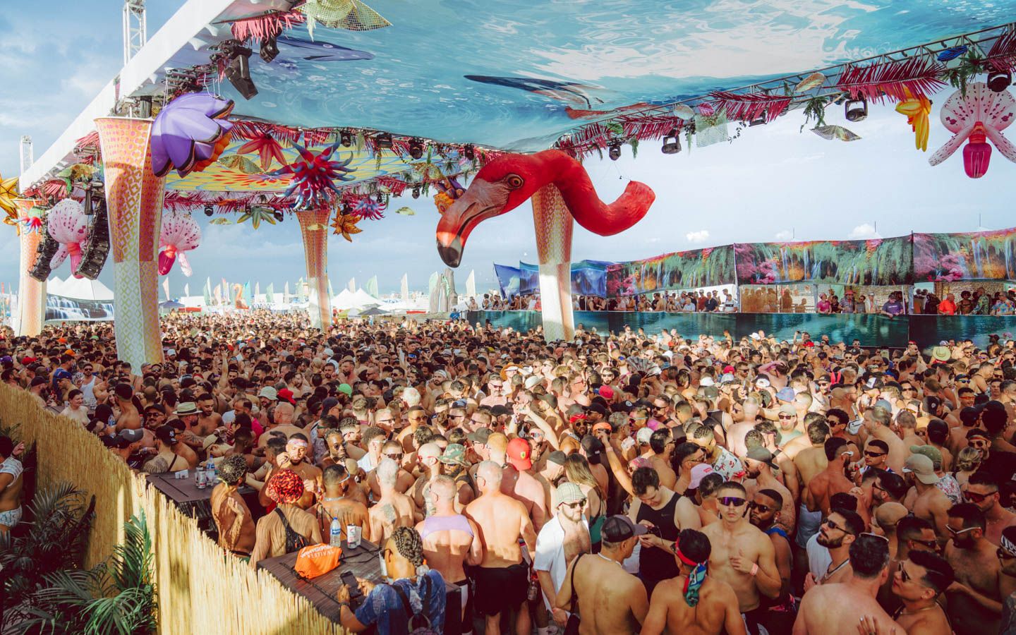 Crowd under the Winter Party Festival Beach Party tent on South Beach, flamingo sculpture overhead