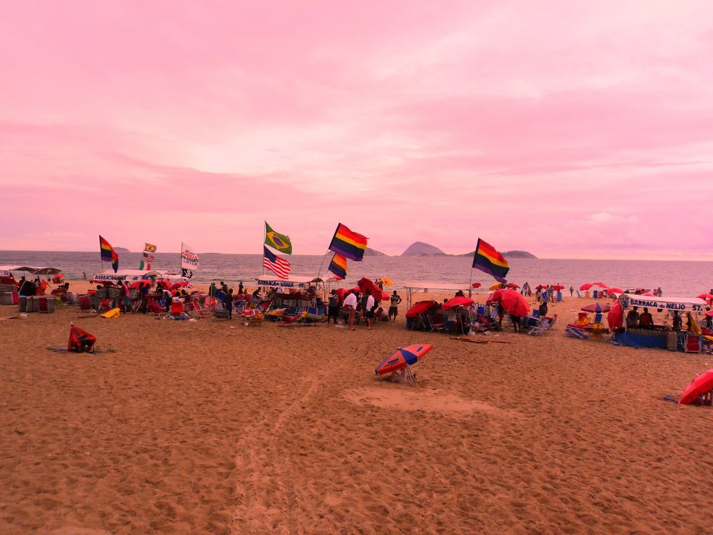 Rainbow flags and beach kiosks on the sand at Posto 9, Ipanema