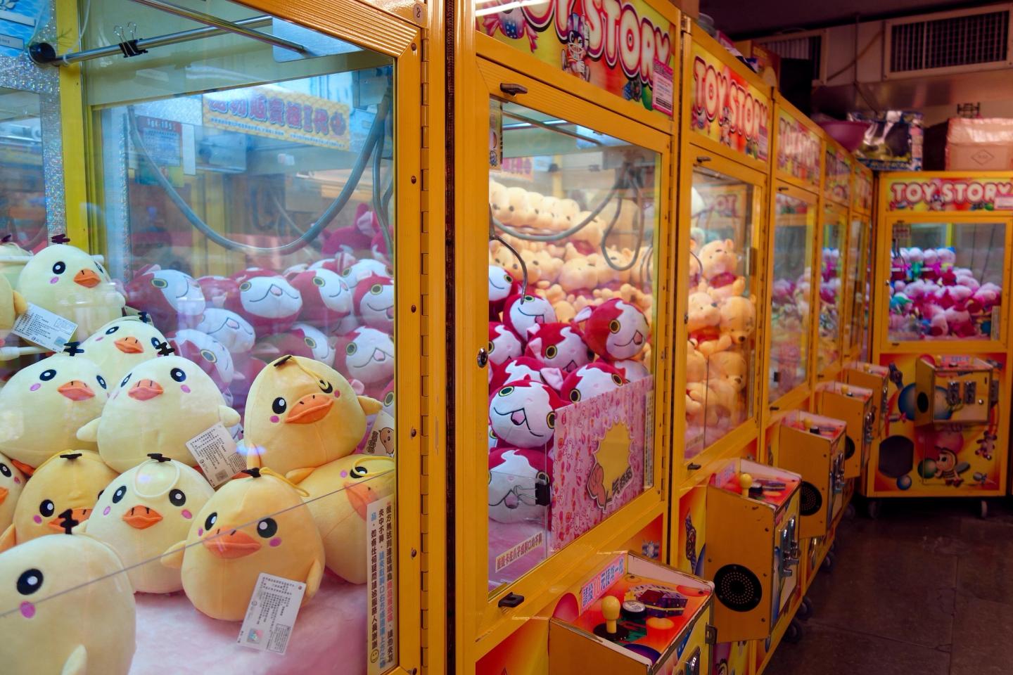 Colorful claw machines glowing at night in Ximending