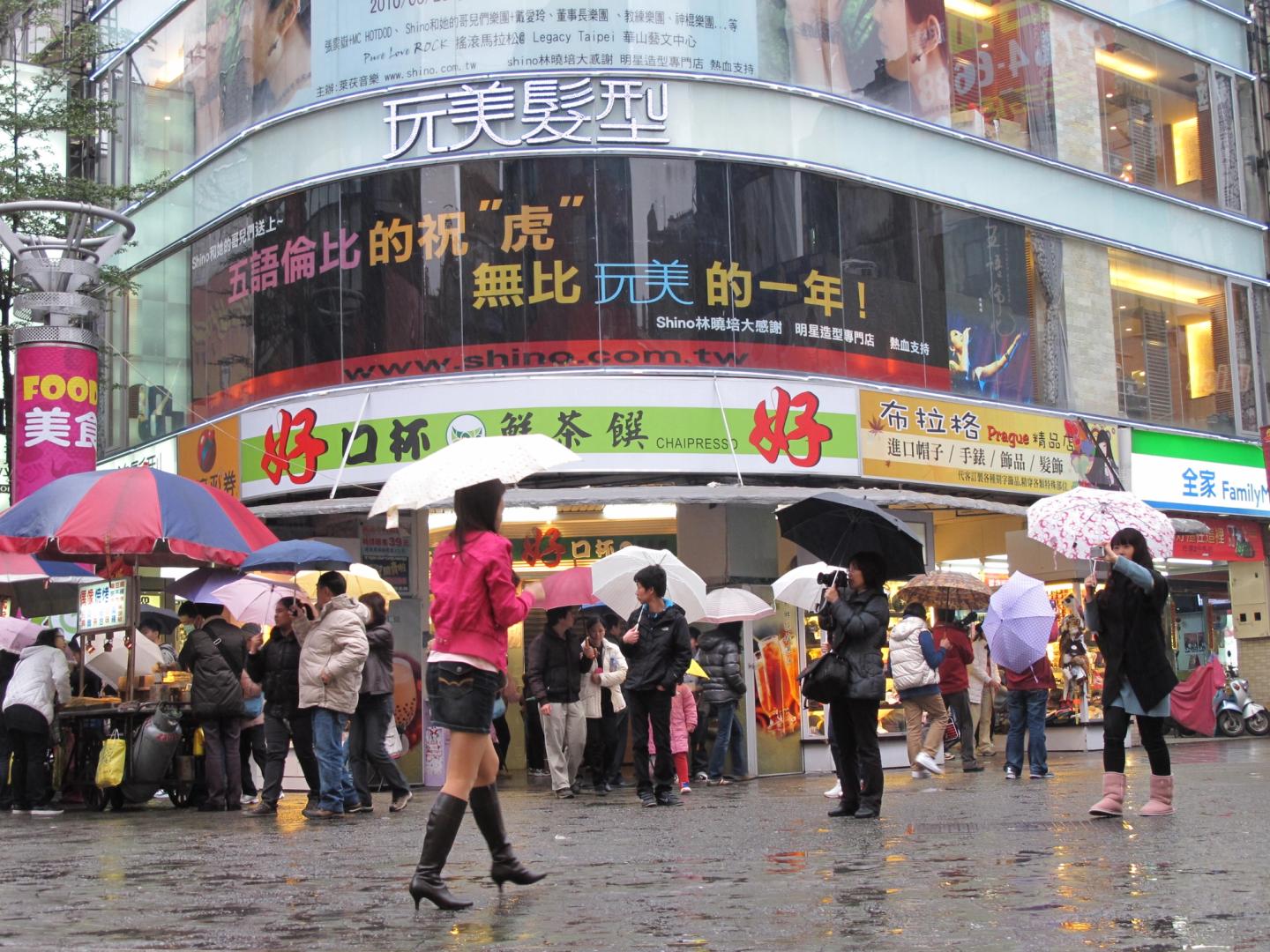 People walking beneath signs in Ximending