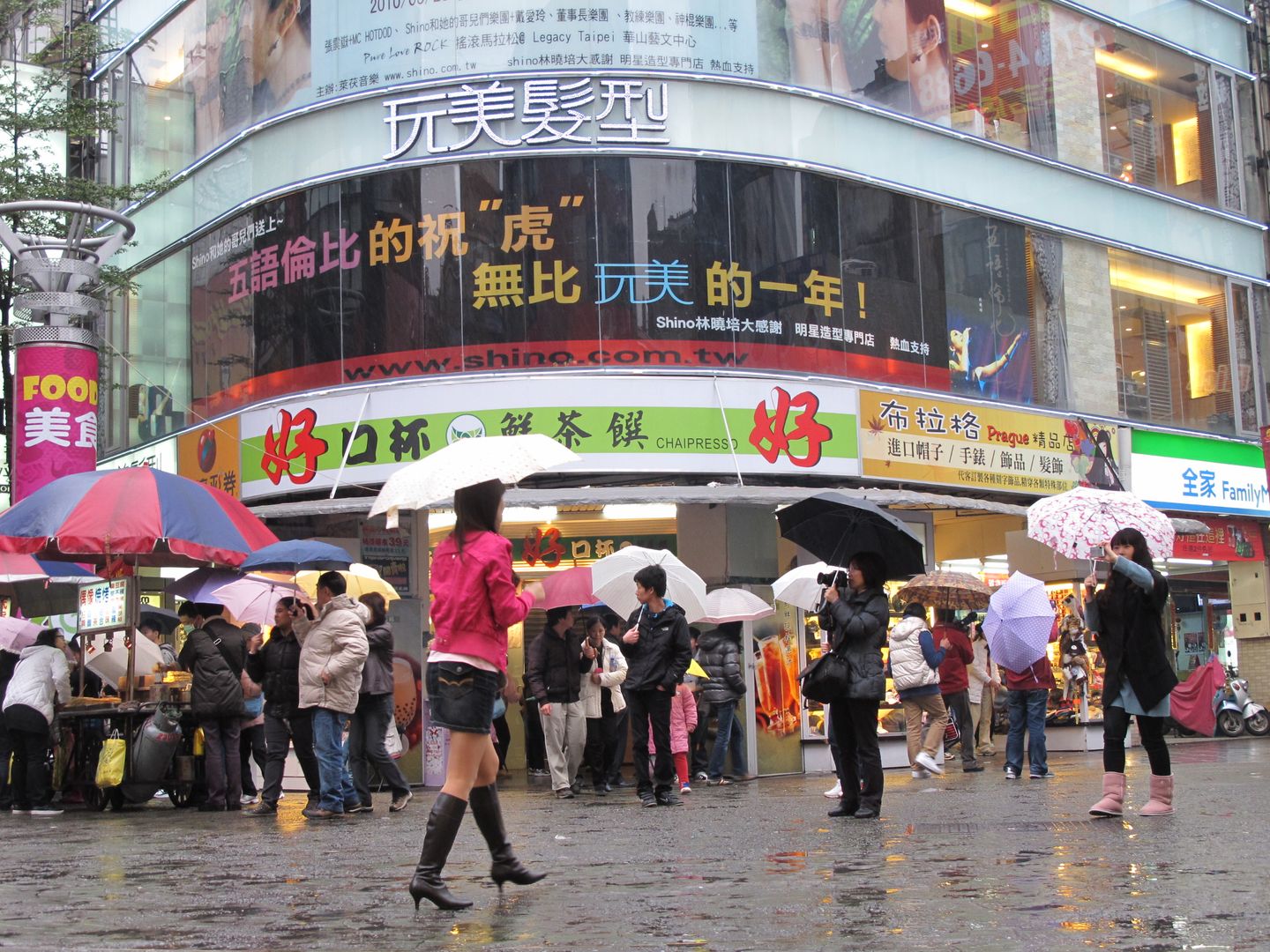 People walking beneath signs in Ximending
