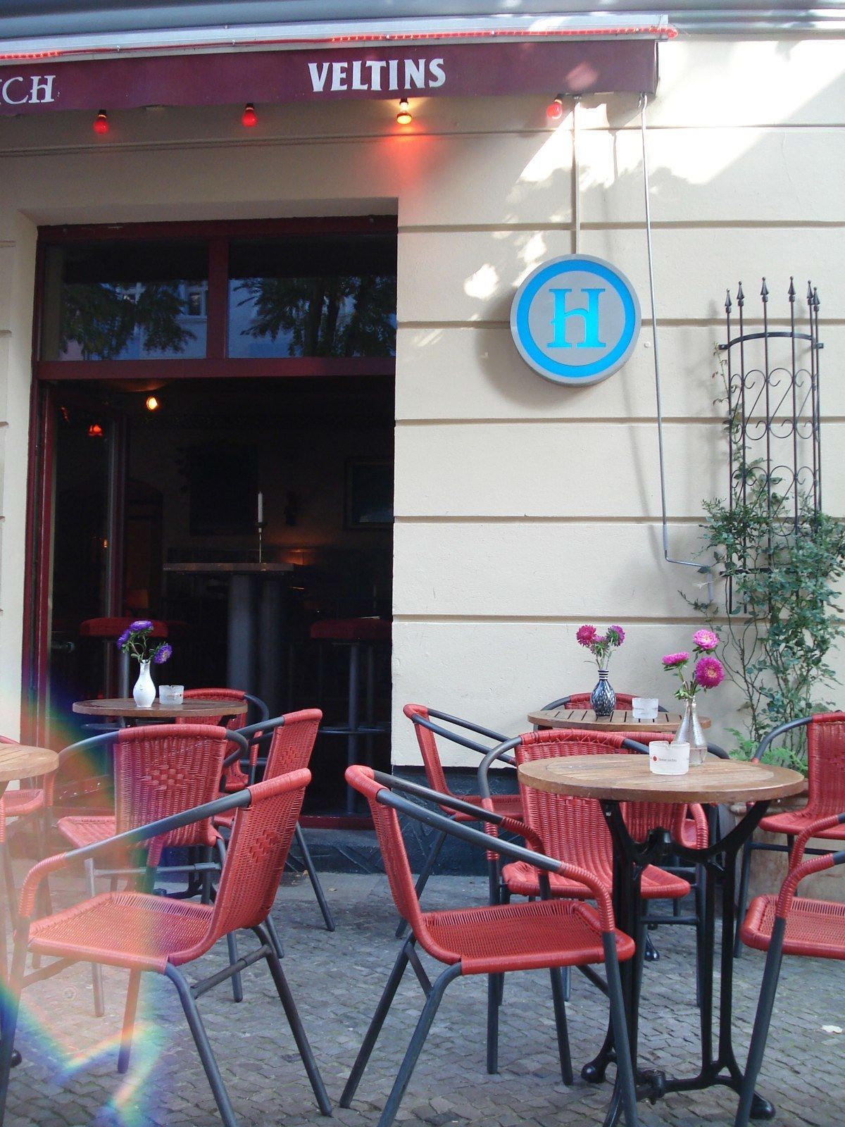 Cafe-Bar Himmelreich terrace on Simon-Dach-Straße with red chairs and H sign