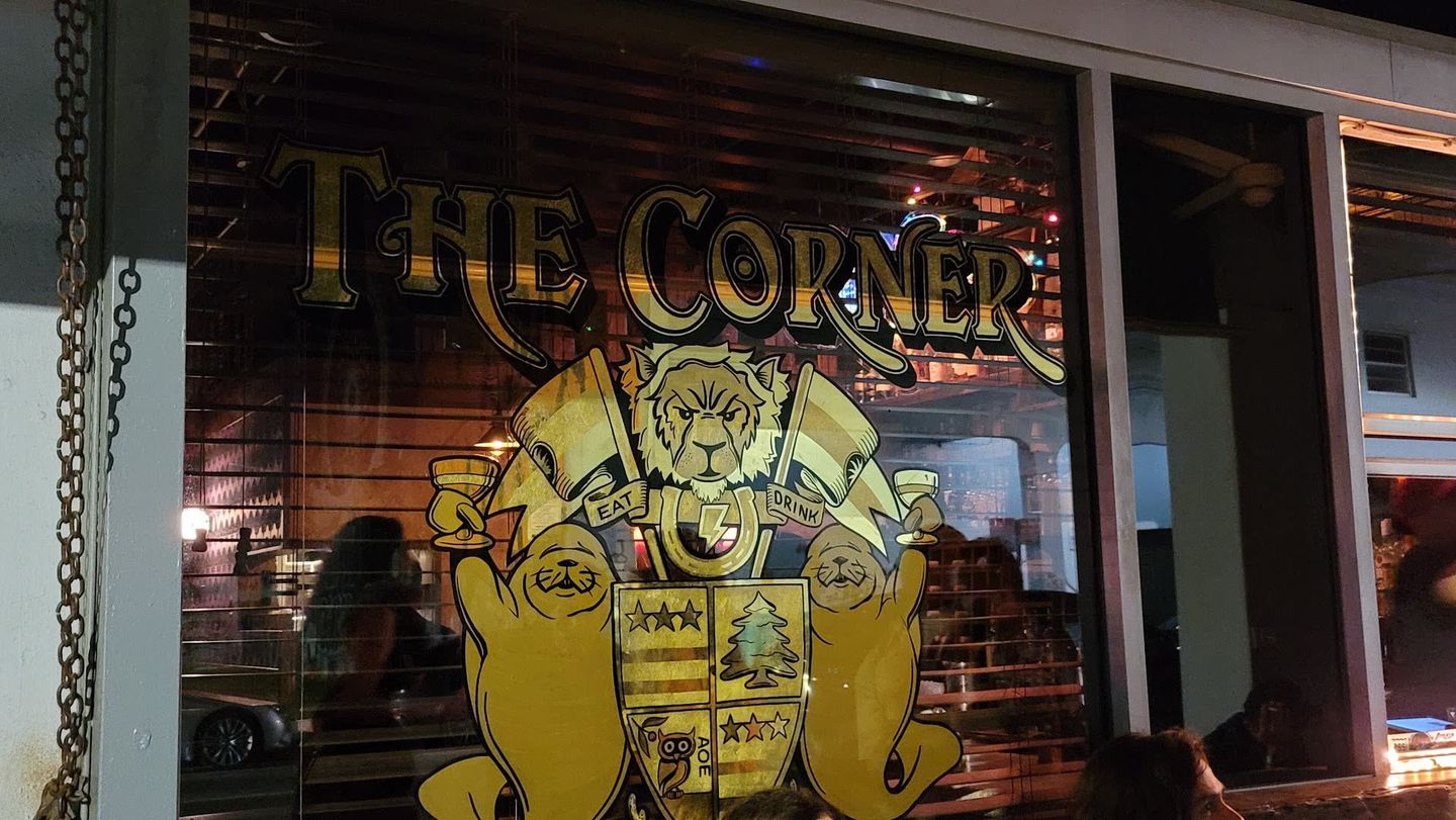 The Corner window sign with crest and manatees on North Miami Avenue