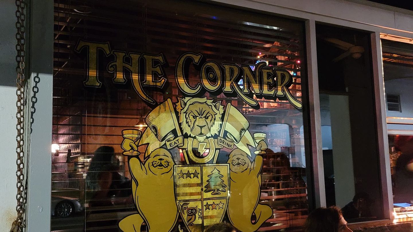 The Corner window sign with crest and manatees on North Miami Avenue