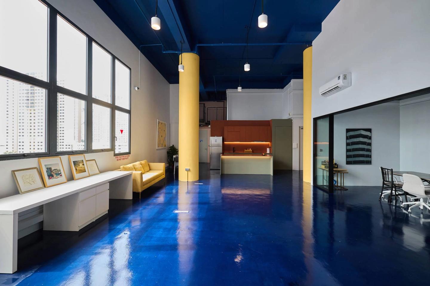 Blue and yellow interior of Proud Spaces on Alexandra Road in Singapore