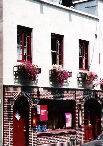 Stonewall Inn storefront on Christopher Street with the neon sign and rainbow flags