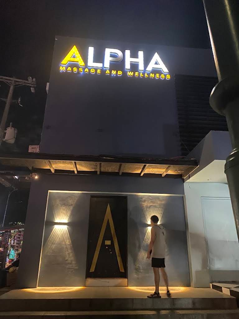 Night entrance and Alpha Massage and Wellness sign in Quezon City