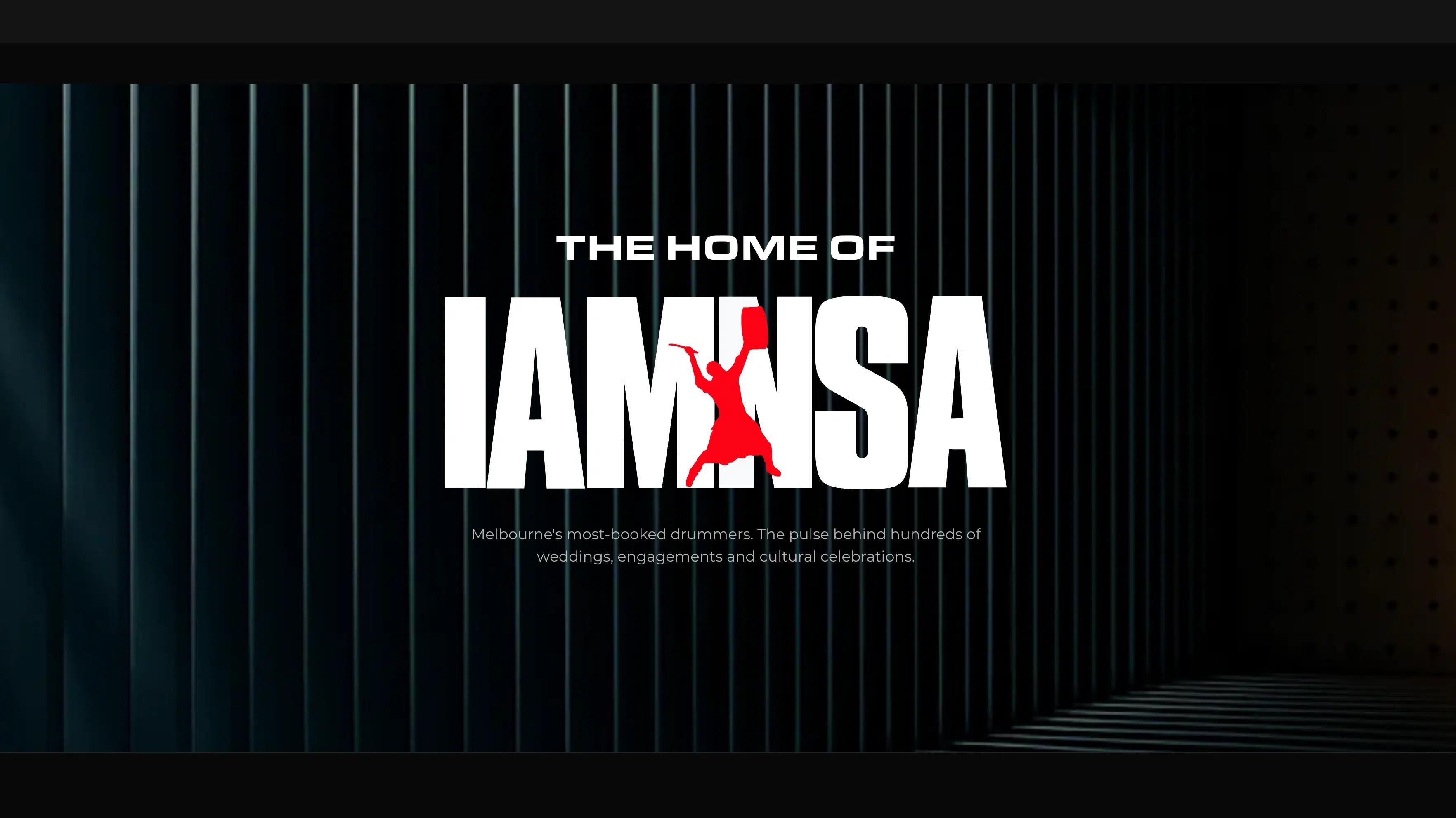 IAMNSA logo with a red drummer silhouette beneath "The home of", set against a dark architectural background.