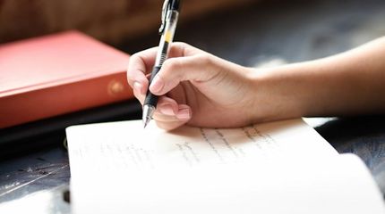 Main qui écrit des notes manuscrites