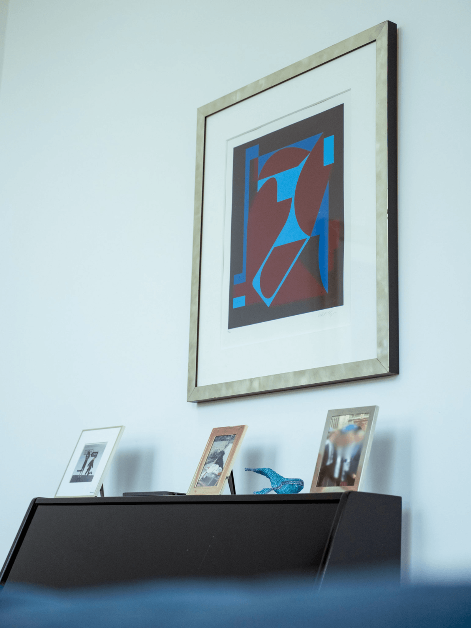 Kent home interiors abstract framed artwork above upright piano with styled photographs