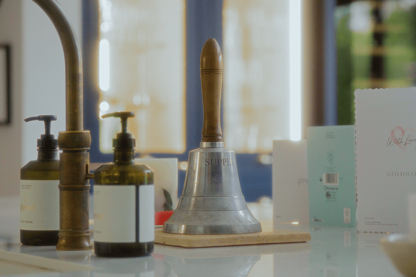 Beckenham home interiors kitchen island styling with brass tap, soap dispensers and vintage dinner bell
