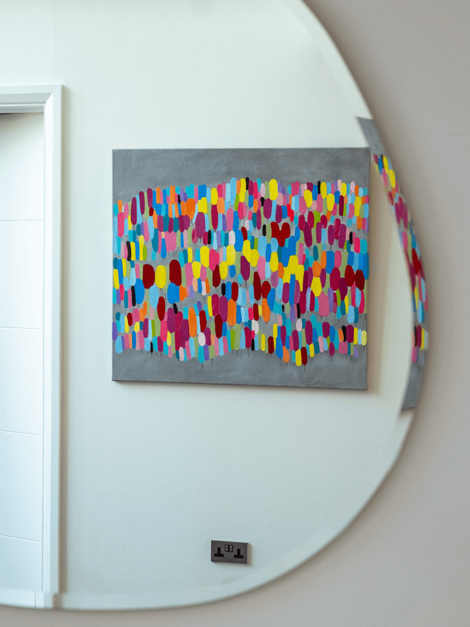 Sevenoaks interior design with curved wall mirror reflecting colourful contemporary artwork