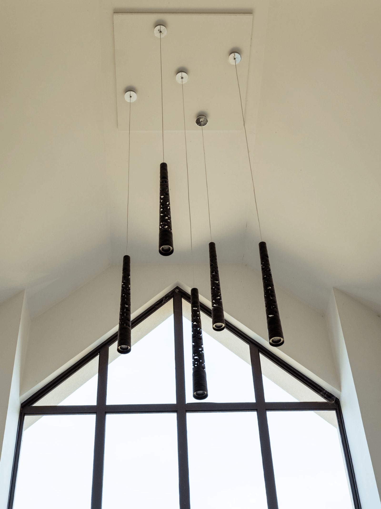 Sevenoaks interior design with sculptural pendant lighting above a double-height stairwell window